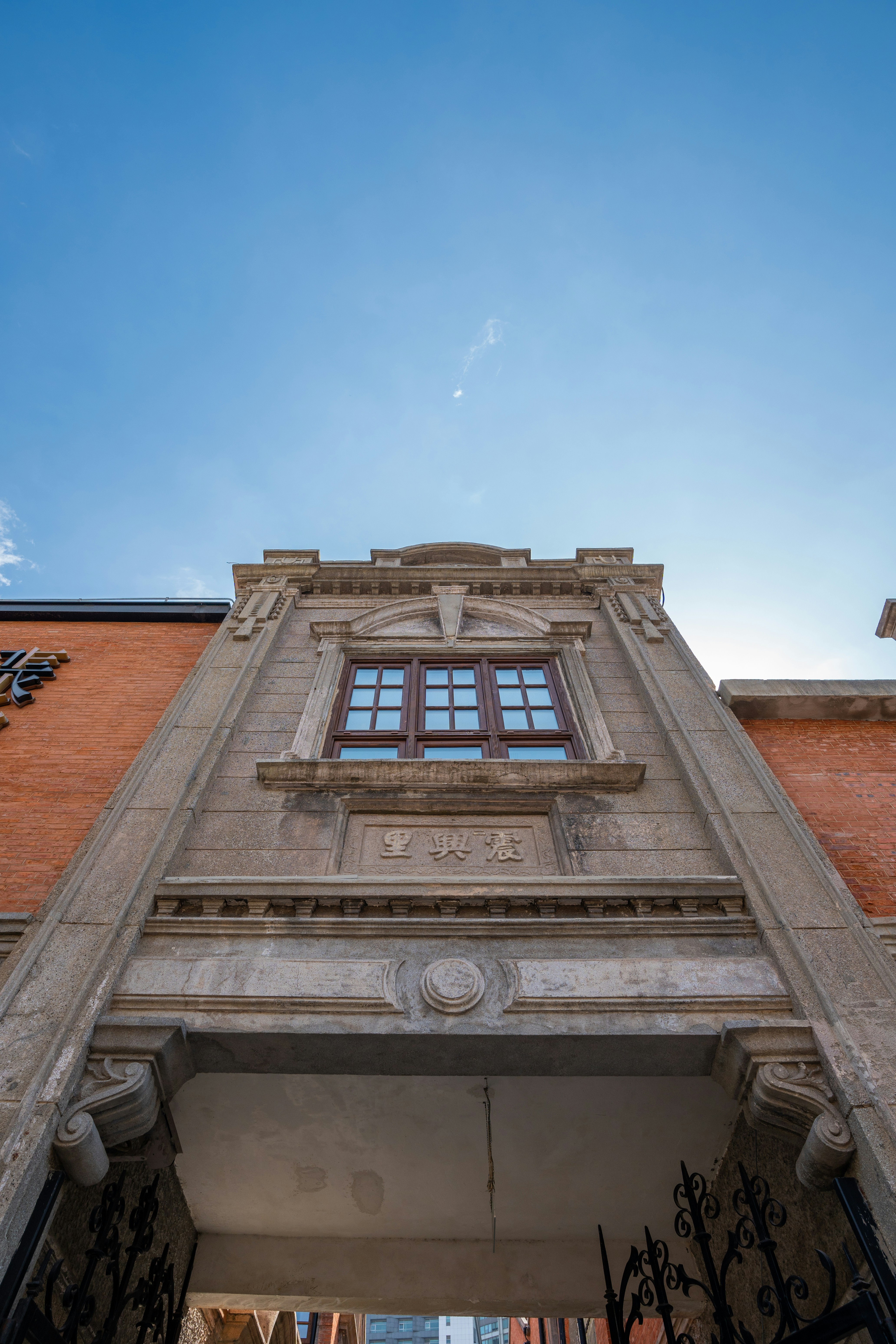 Ornate building facade with a window under blue sky