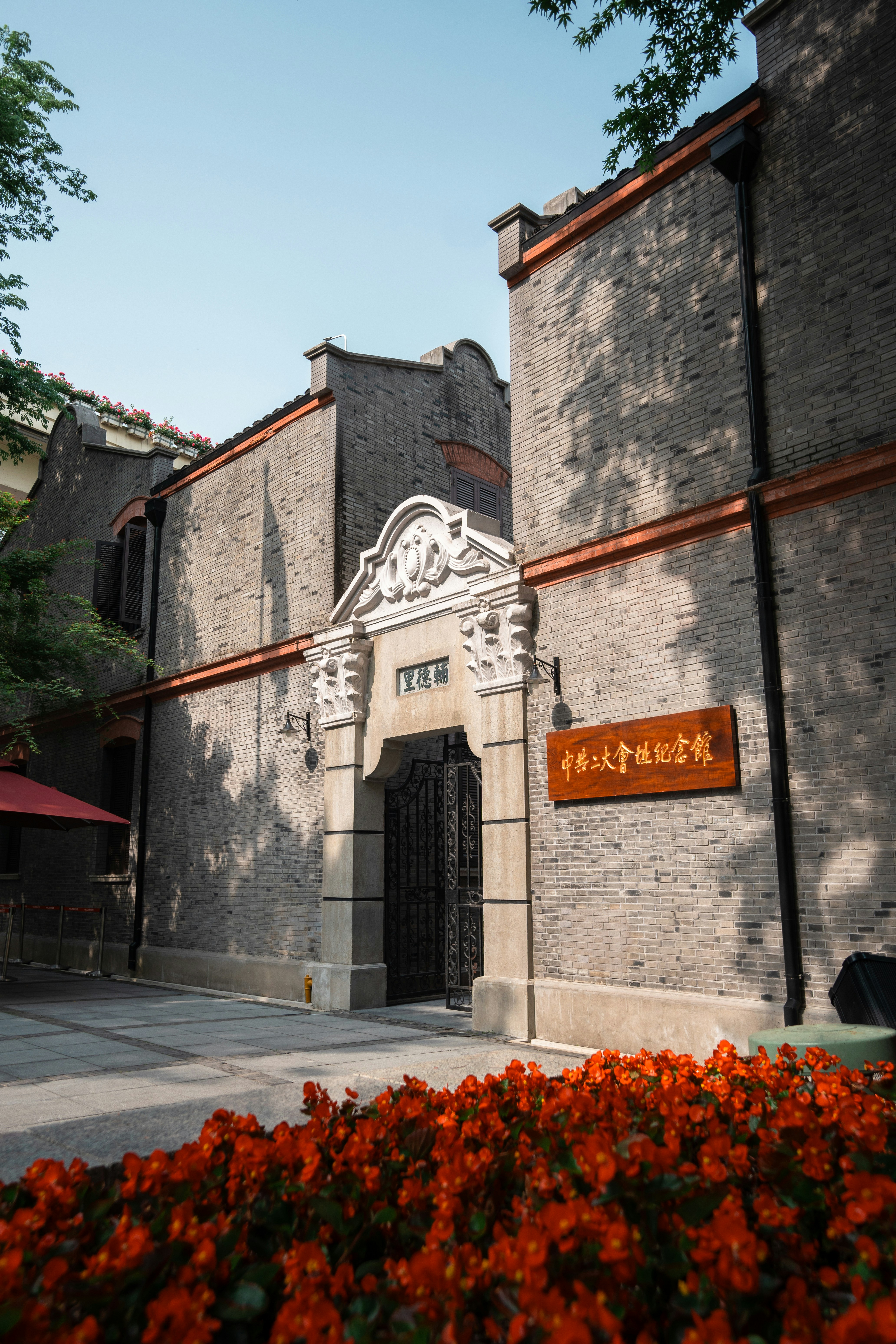 Historic brick building with ornate entrance and flowers