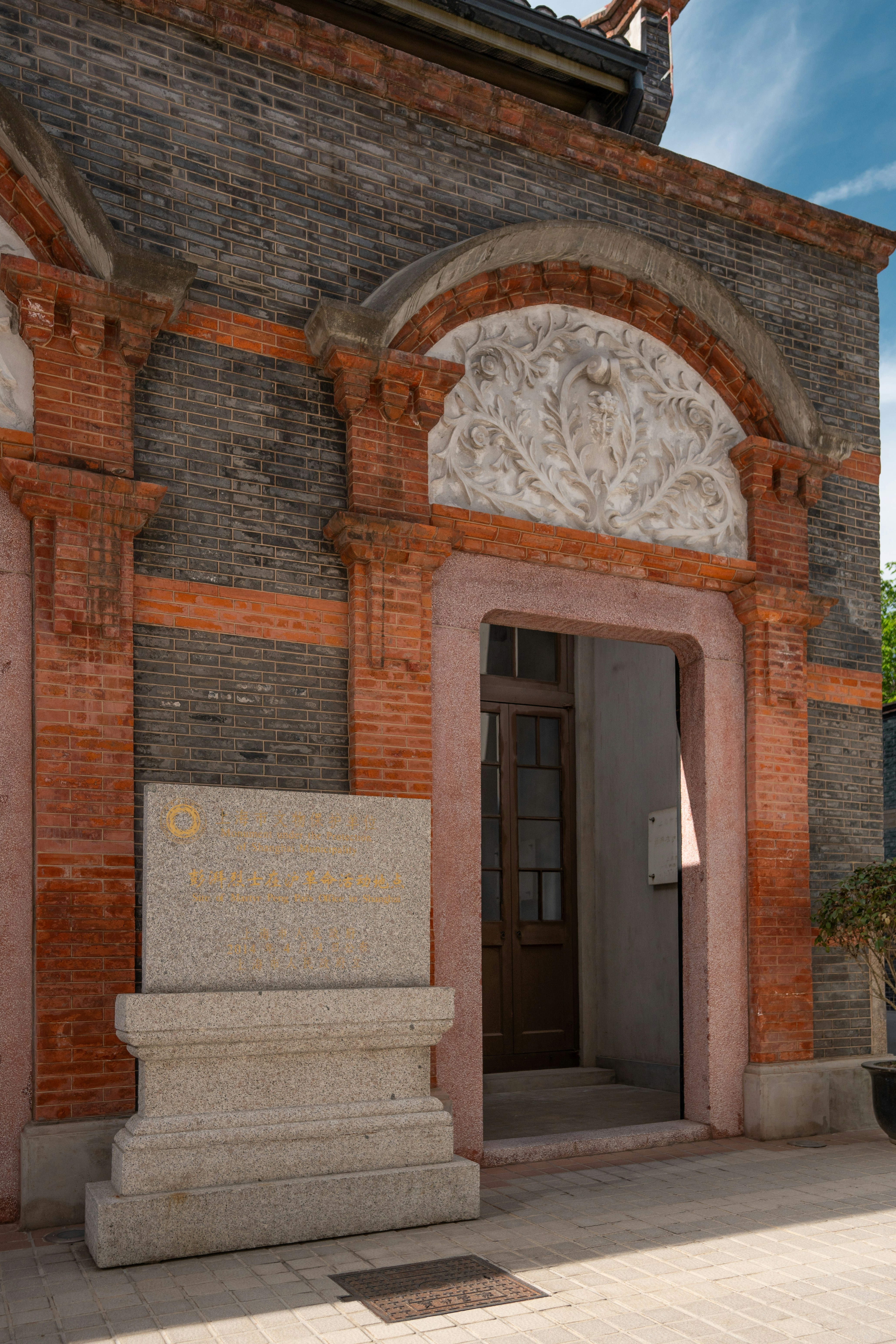 Stone monument in front of brick building entrance