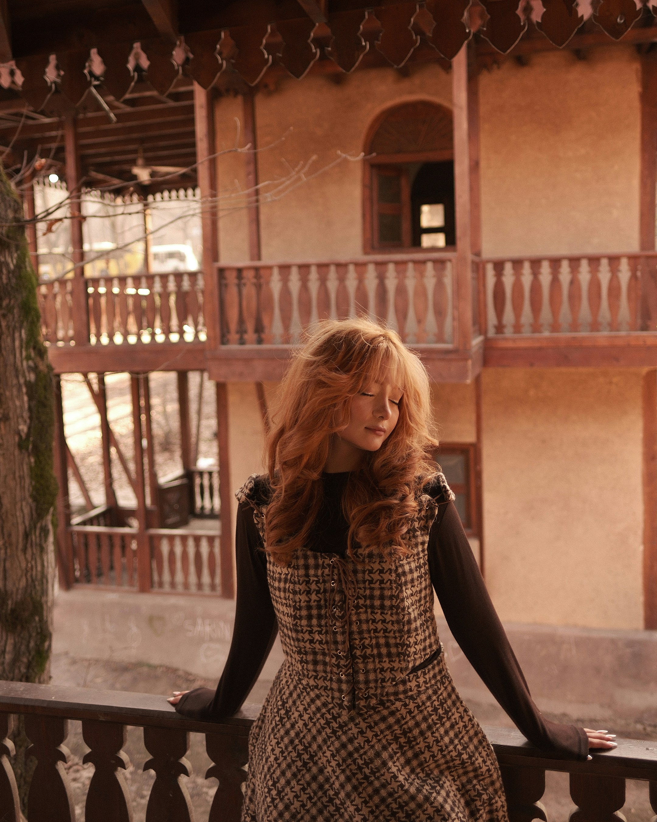 Woman with red hair in a plaid dress outdoors
