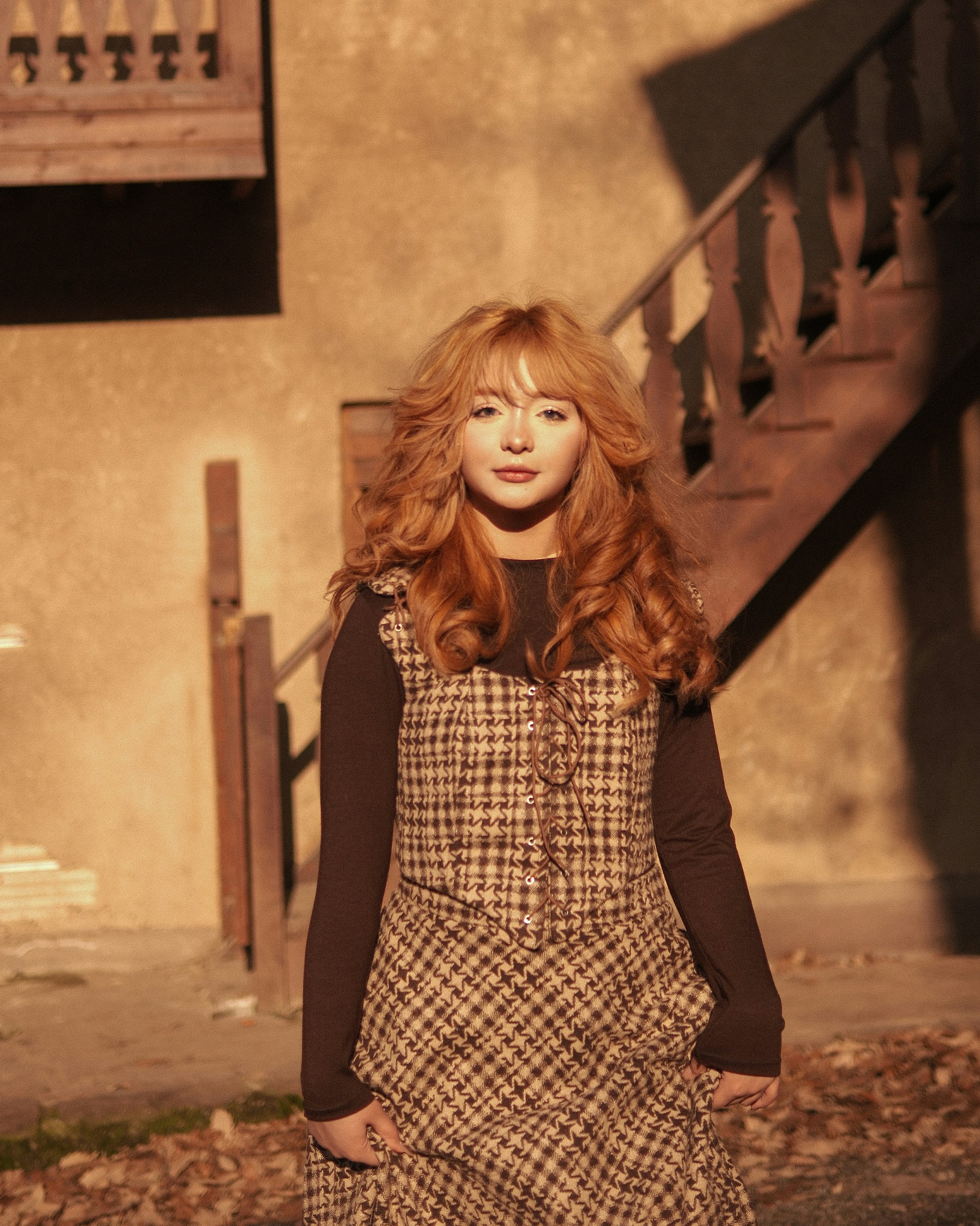 Young woman with long red hair in plaid dress