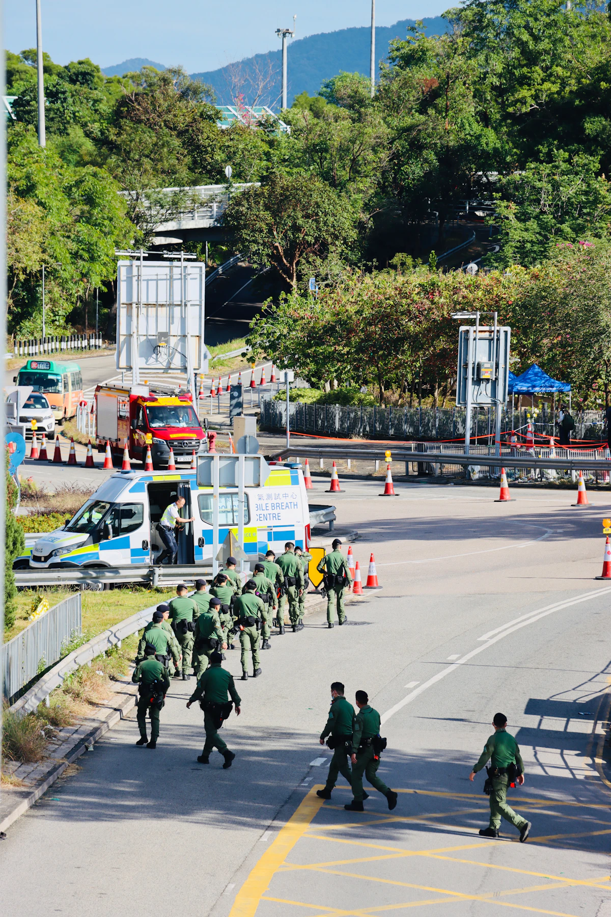 Petugas polisi berjalan di jalan dekat kendaraan darurat