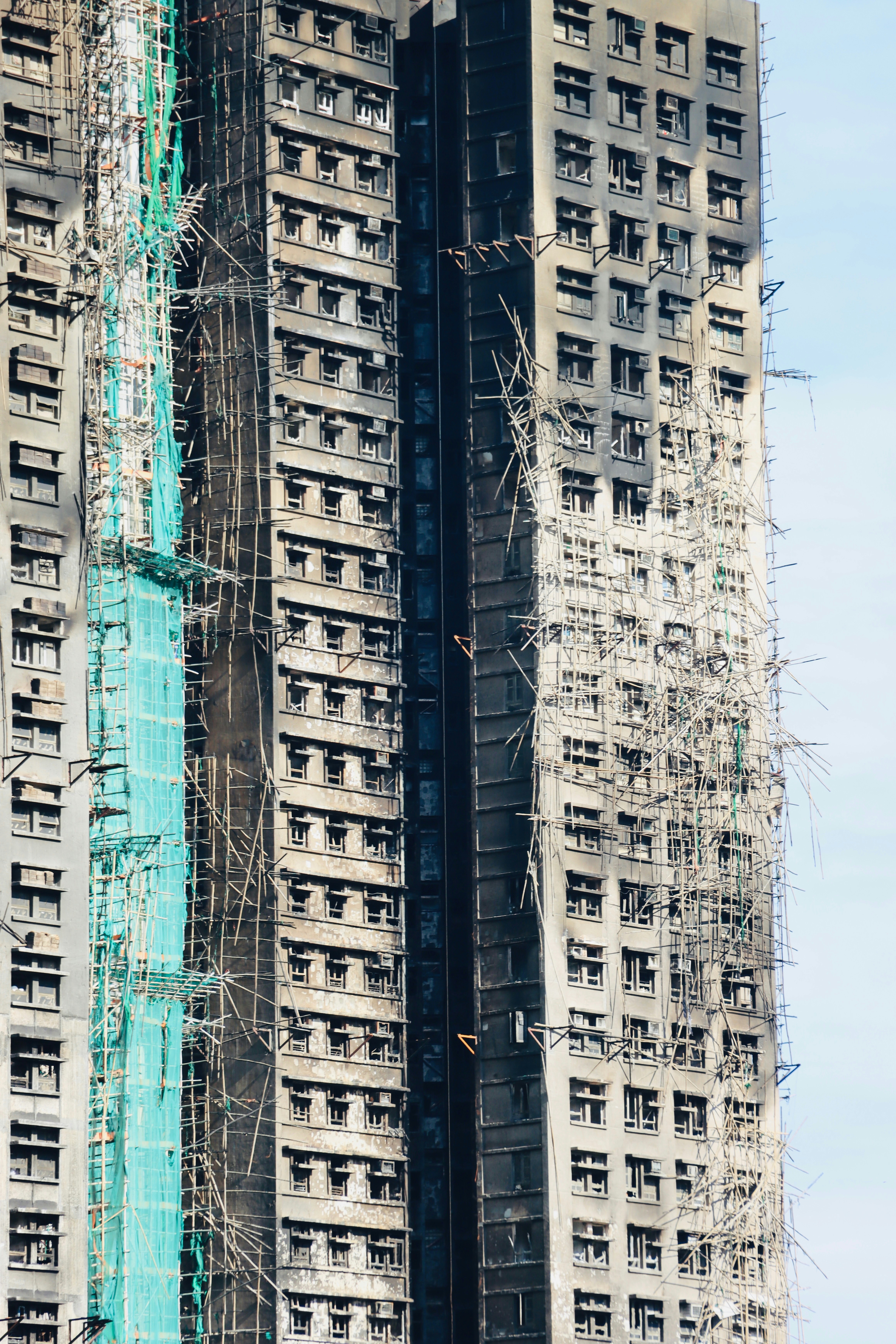 Skyscraper damaged by fire with scaffolding and netting