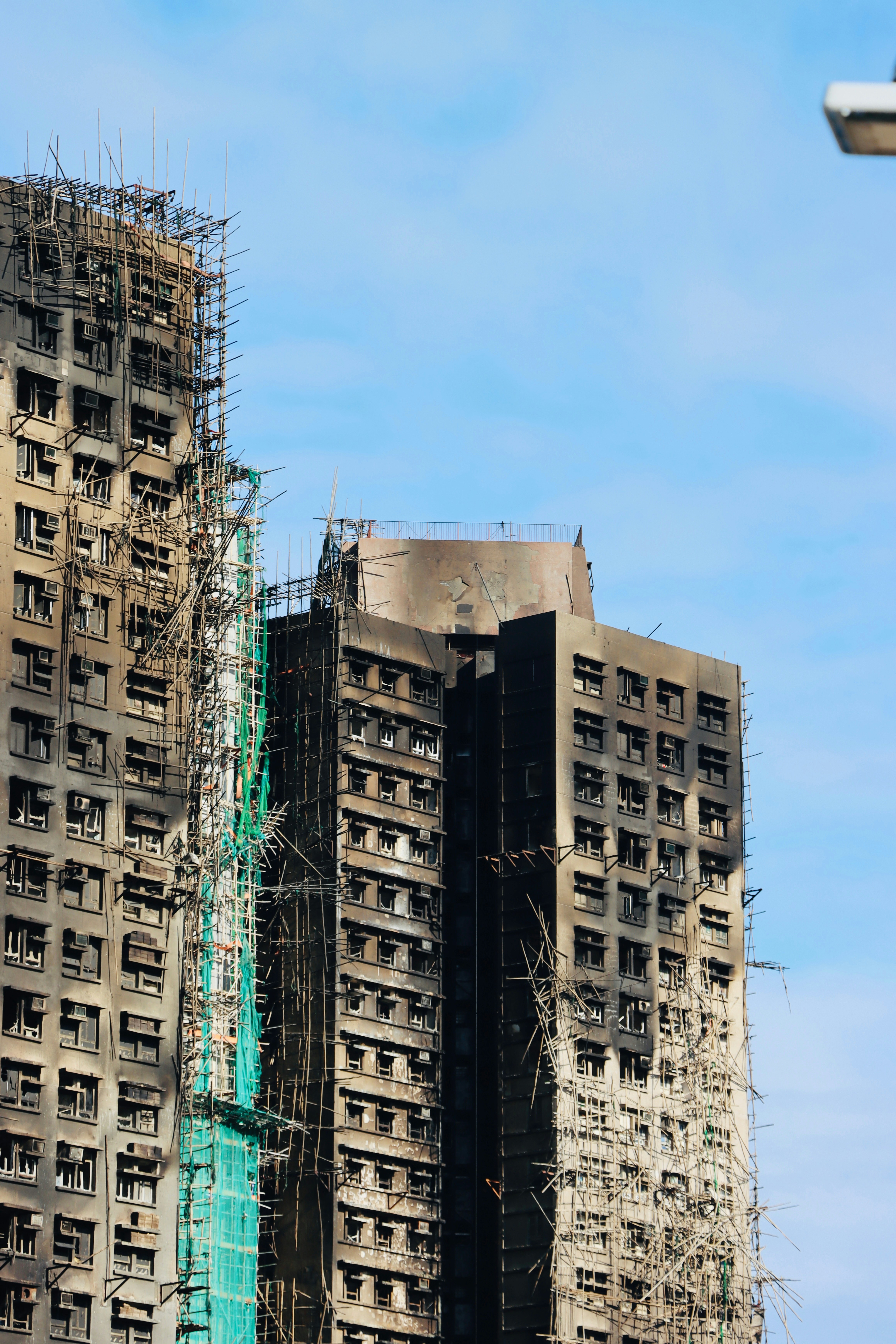 Tall buildings damaged by fire against blue sky.