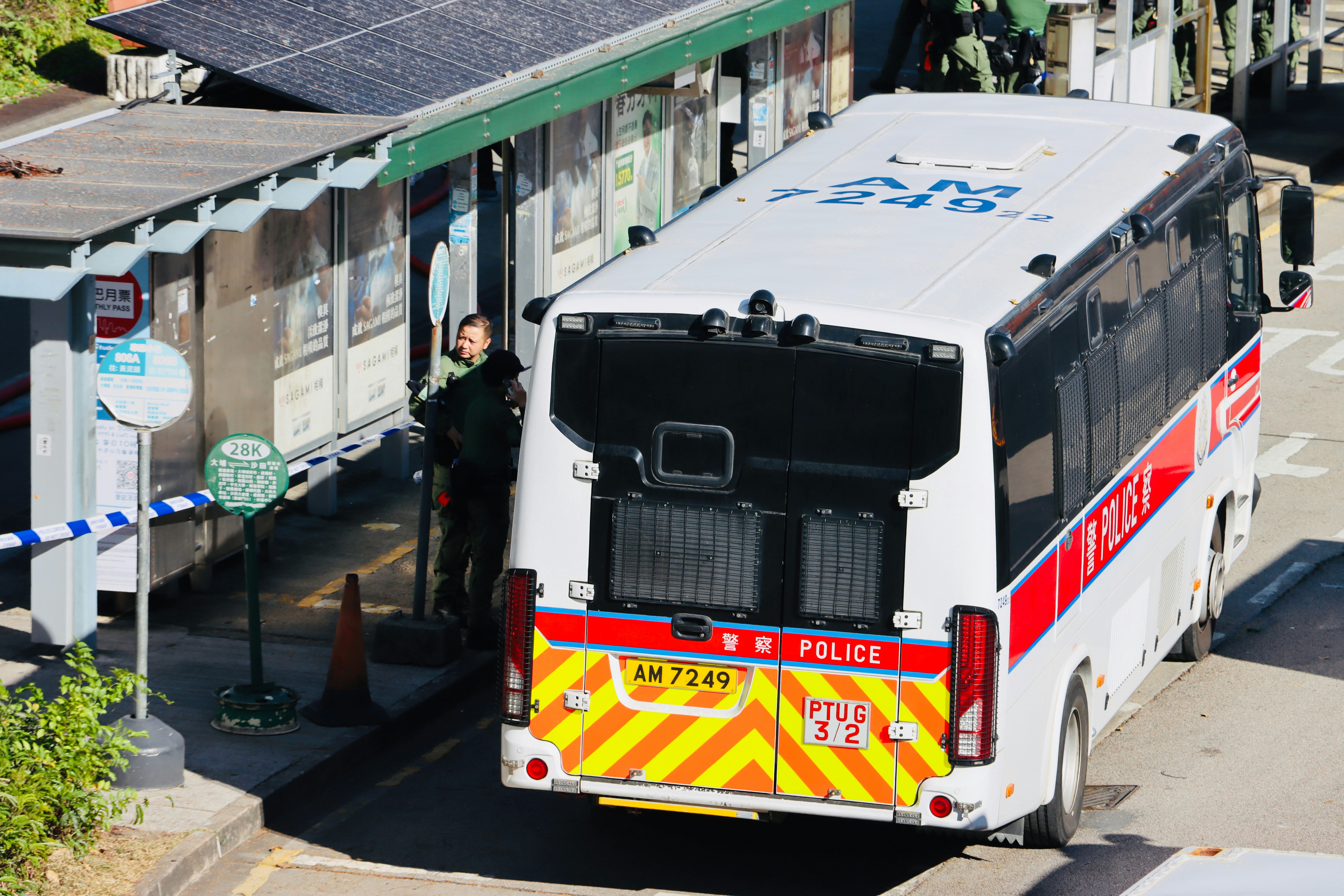 Un bus de police garé à côté d’un arrêt de bus.