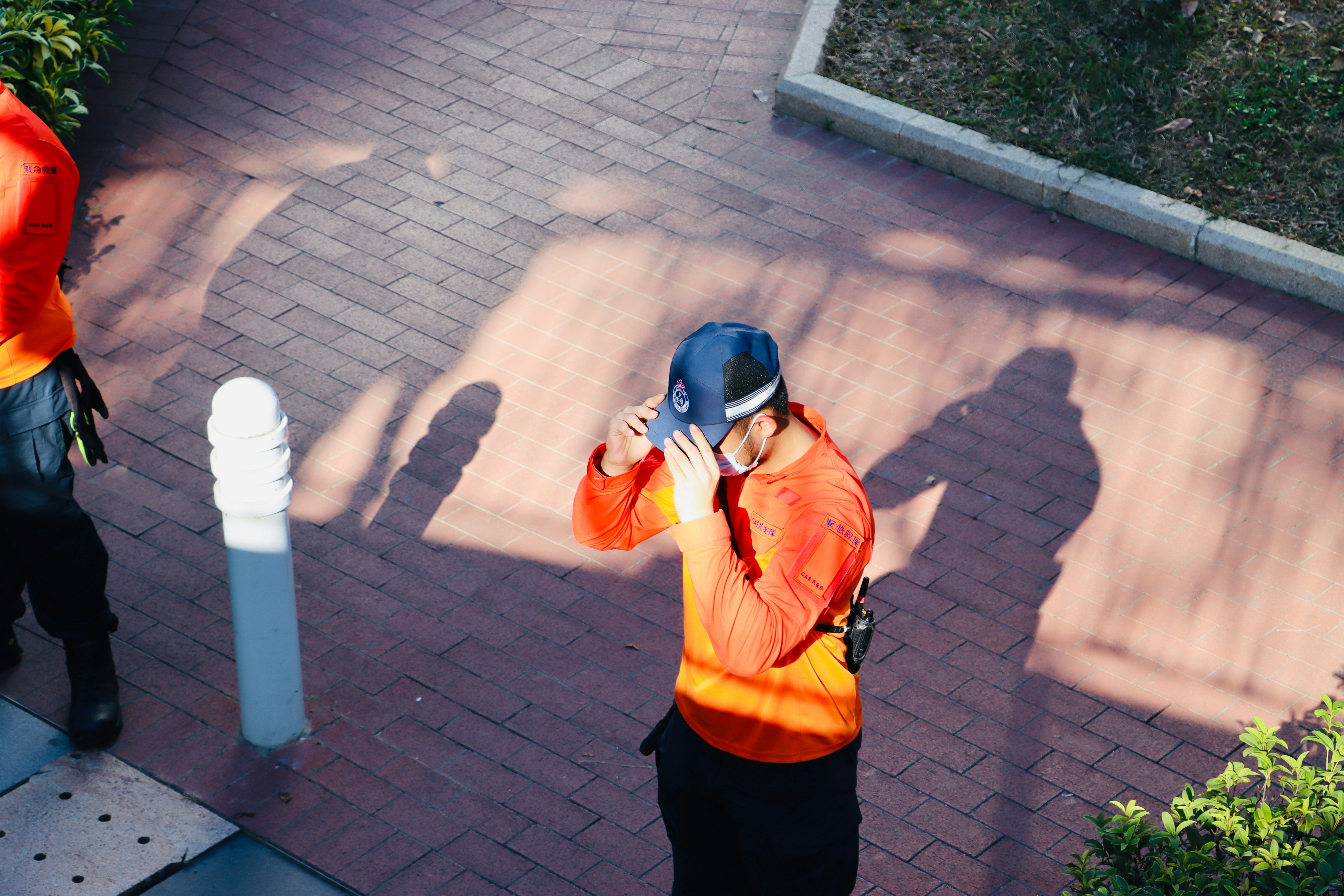 Person adjusting a blue baseball cap outdoors