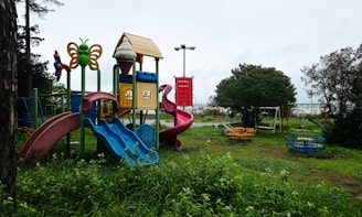 Colorful playground equipment in a grassy park setting.