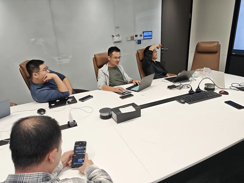 Sales team reviewing pipeline on laptops in a meeting