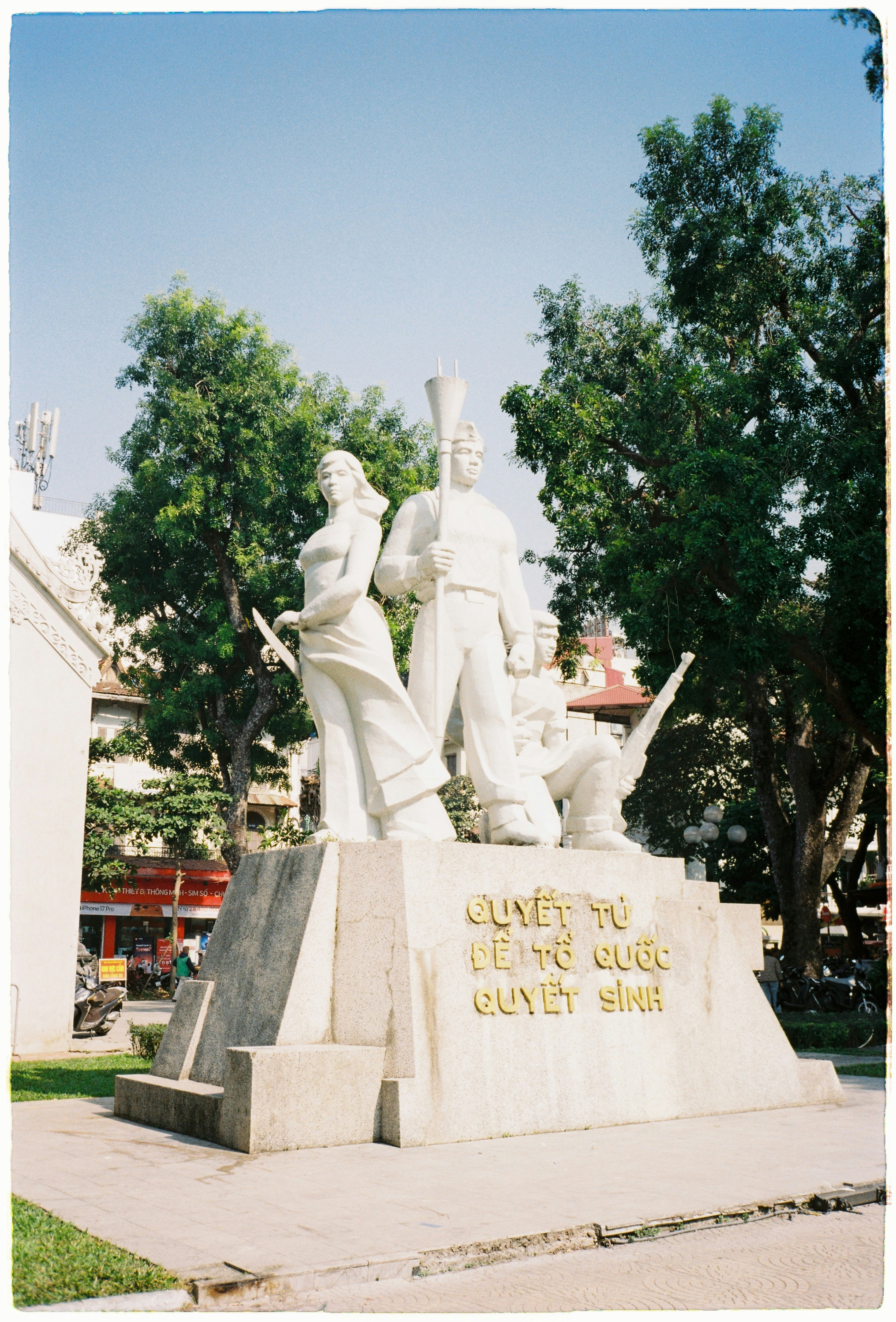 Sculpture of three figures on a stone pedestal.