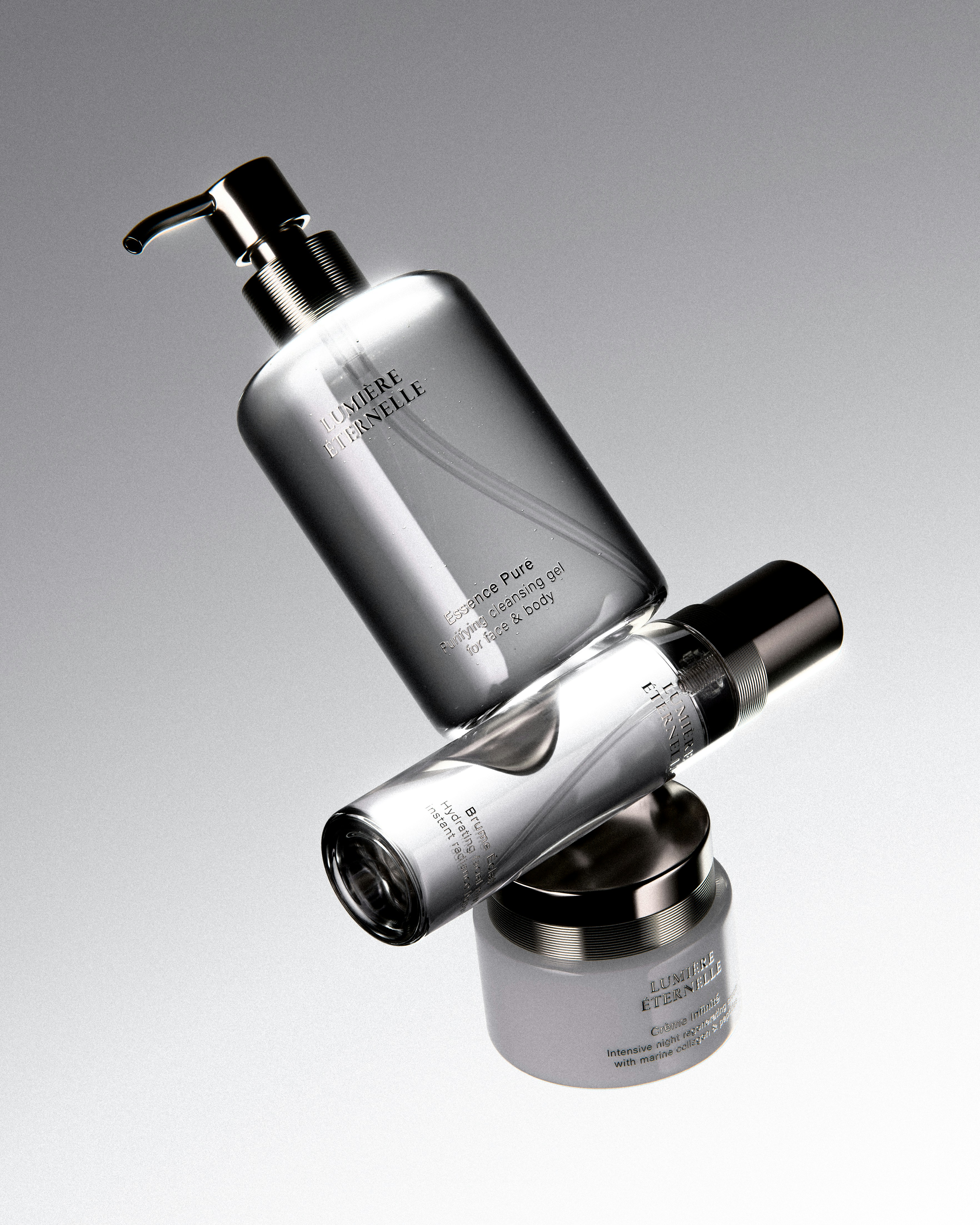 Three silver cosmetic bottles stacked precariously