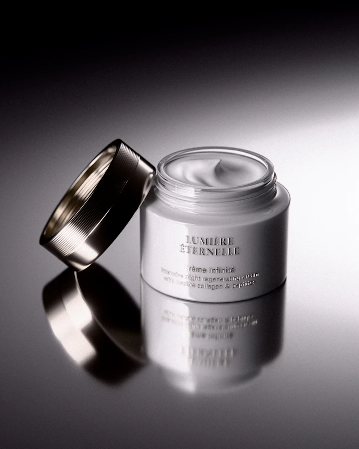 White ceramic face-cream jar with a silver lid, photographed in soft studio light