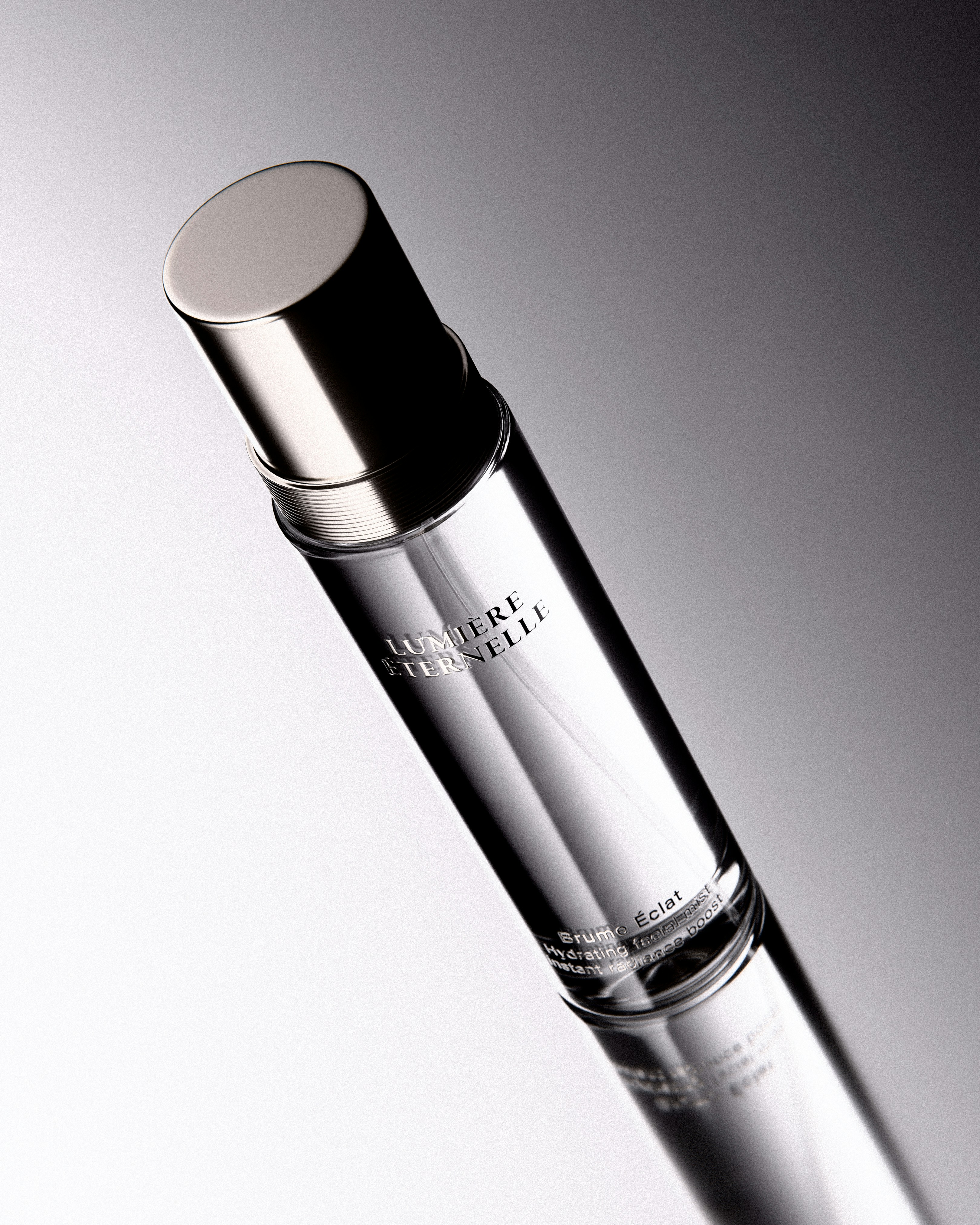 A clear glass perfume bottle with silver cap