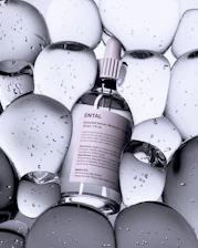 A bottle of serum surrounded by clear, rounded shapes.