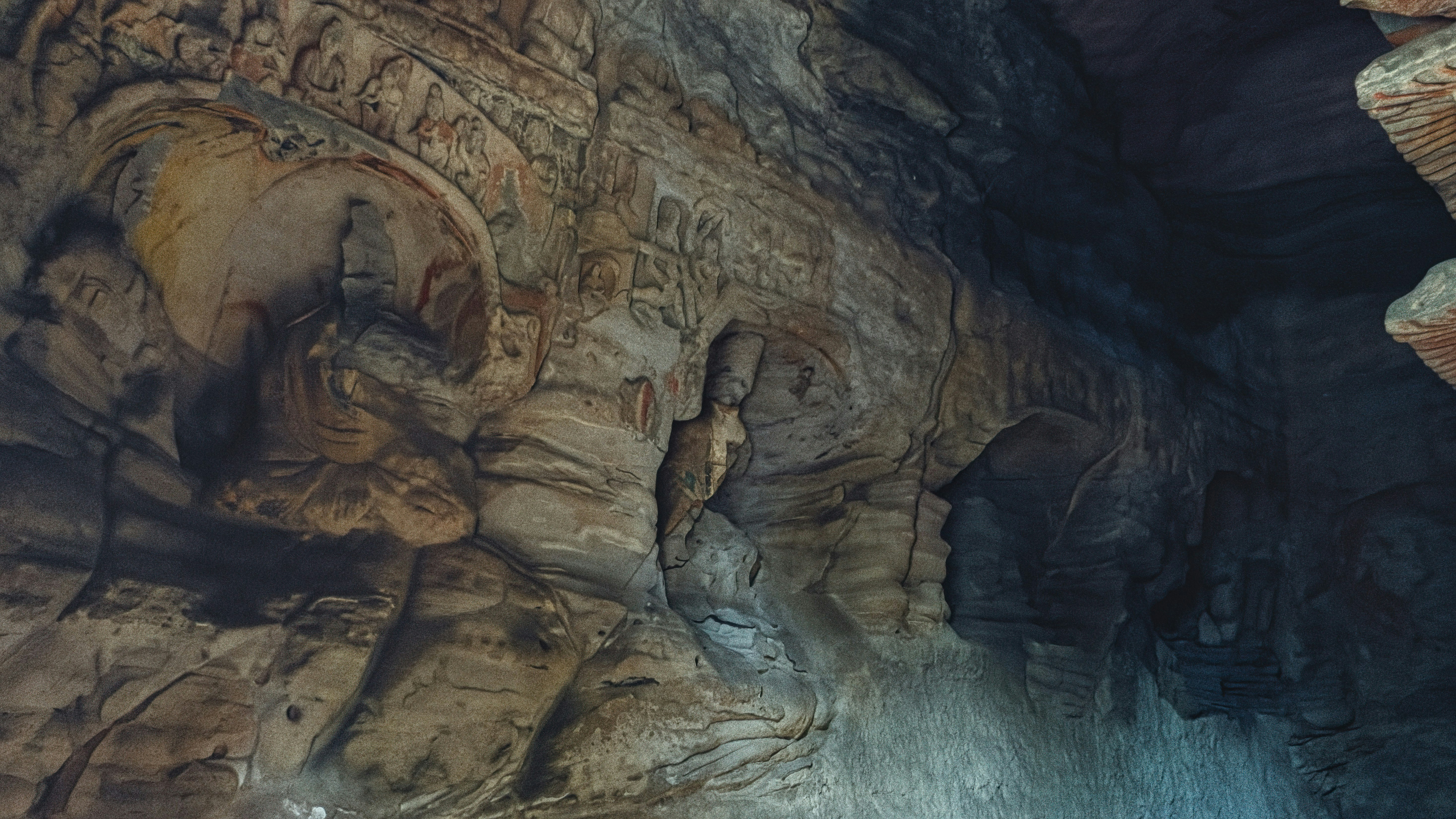 Exploring ancient rock carvings in a cave at dawn, revealing intricate details of historical artistry and culture - In a secluded cave at dawn, ancient rock carvings come to life, showcasing intricate figures and scenes from history. The soft light accentuates the artistry of the past.