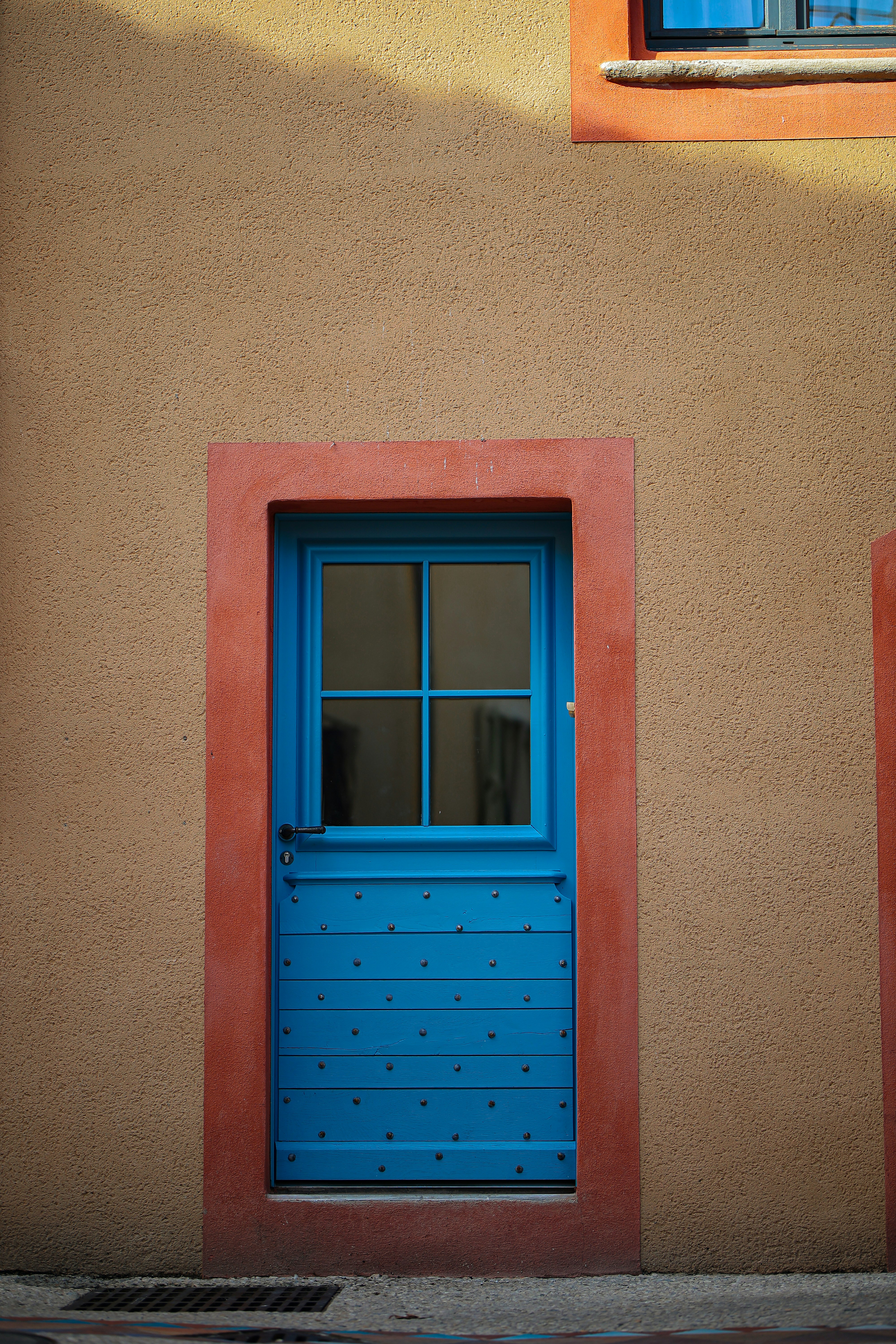 A bright blue door with a glass pane.