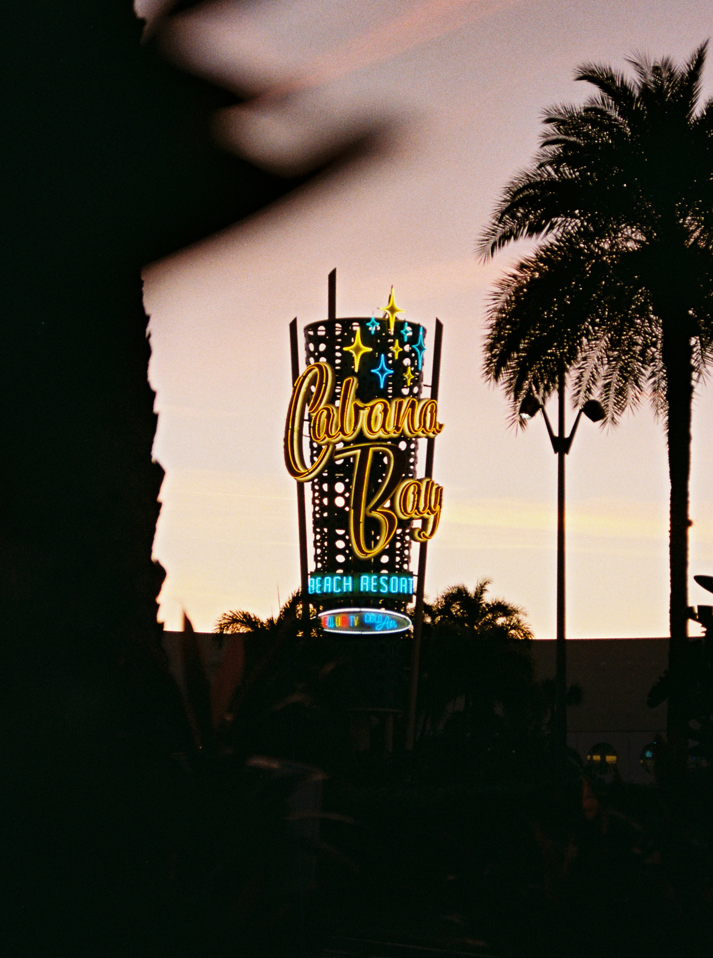 Retro neon sign for cabana bay beach resort at dusk.
