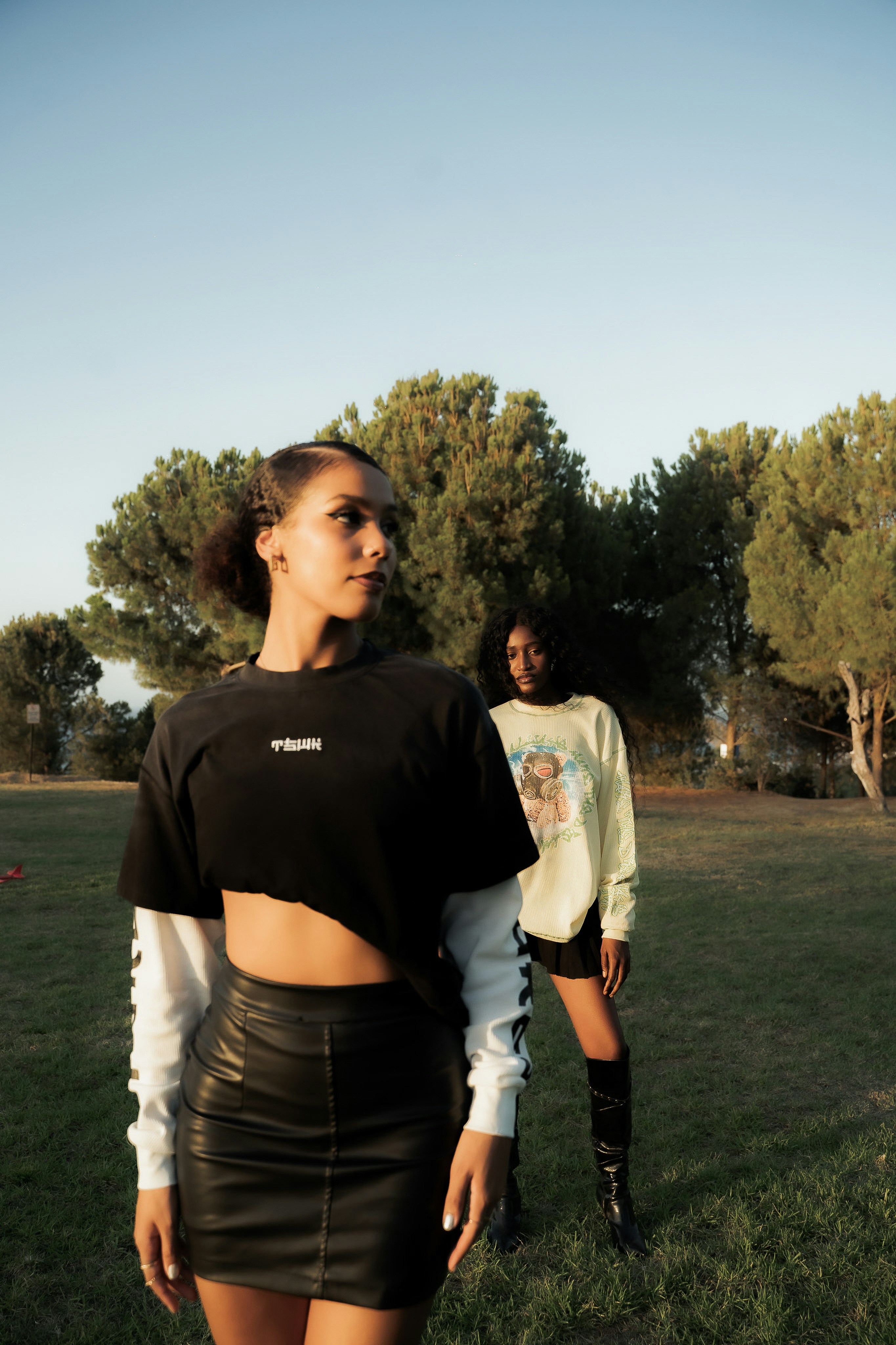 Two women posing in a grassy outdoor setting.