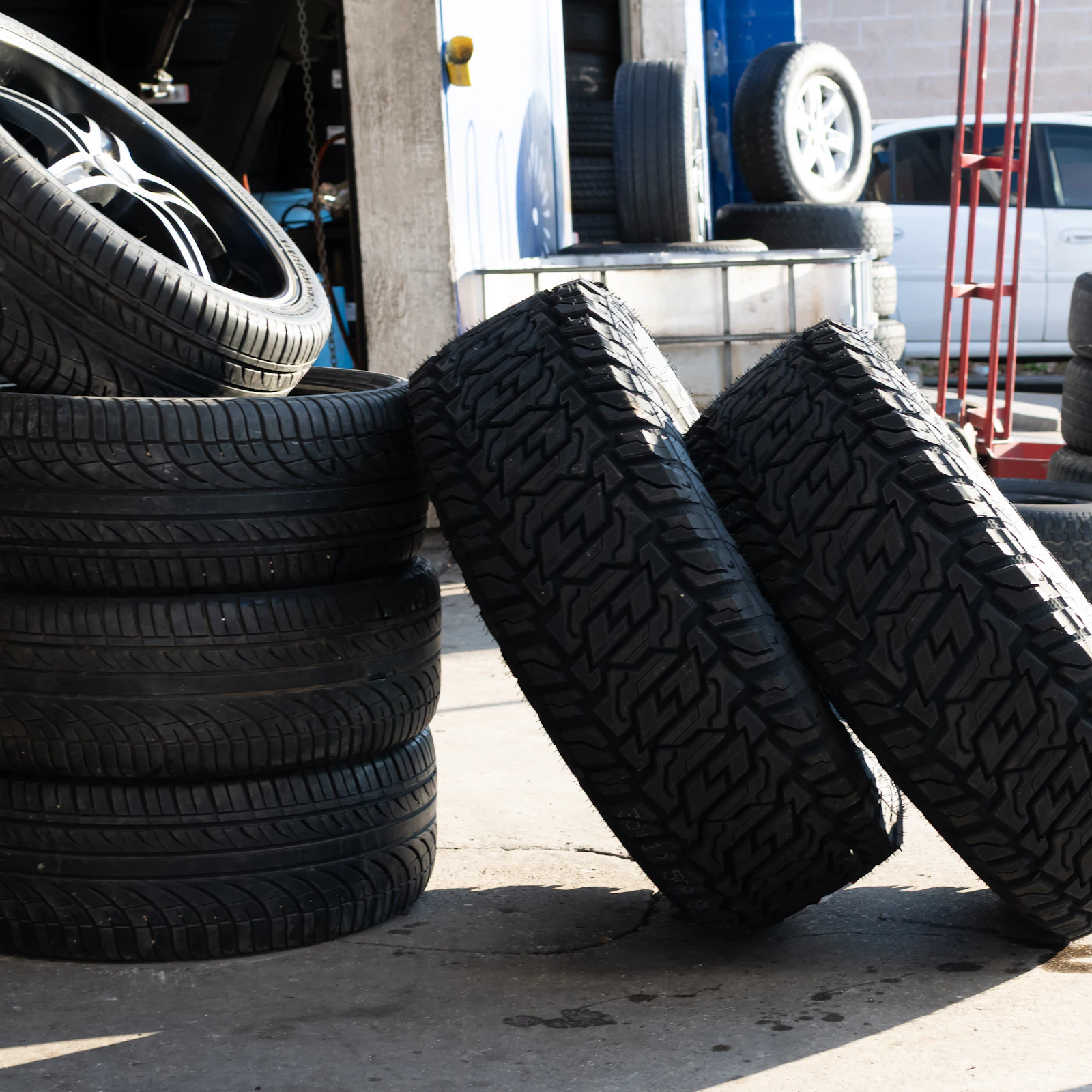 Stacked tires and loose tires leaning together on a shop floor
