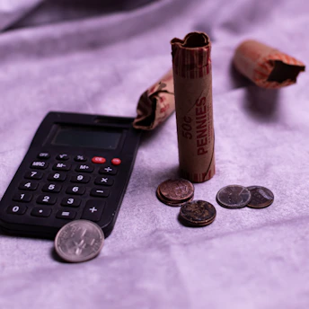 Calculator and rolls of pennies with loose coins.