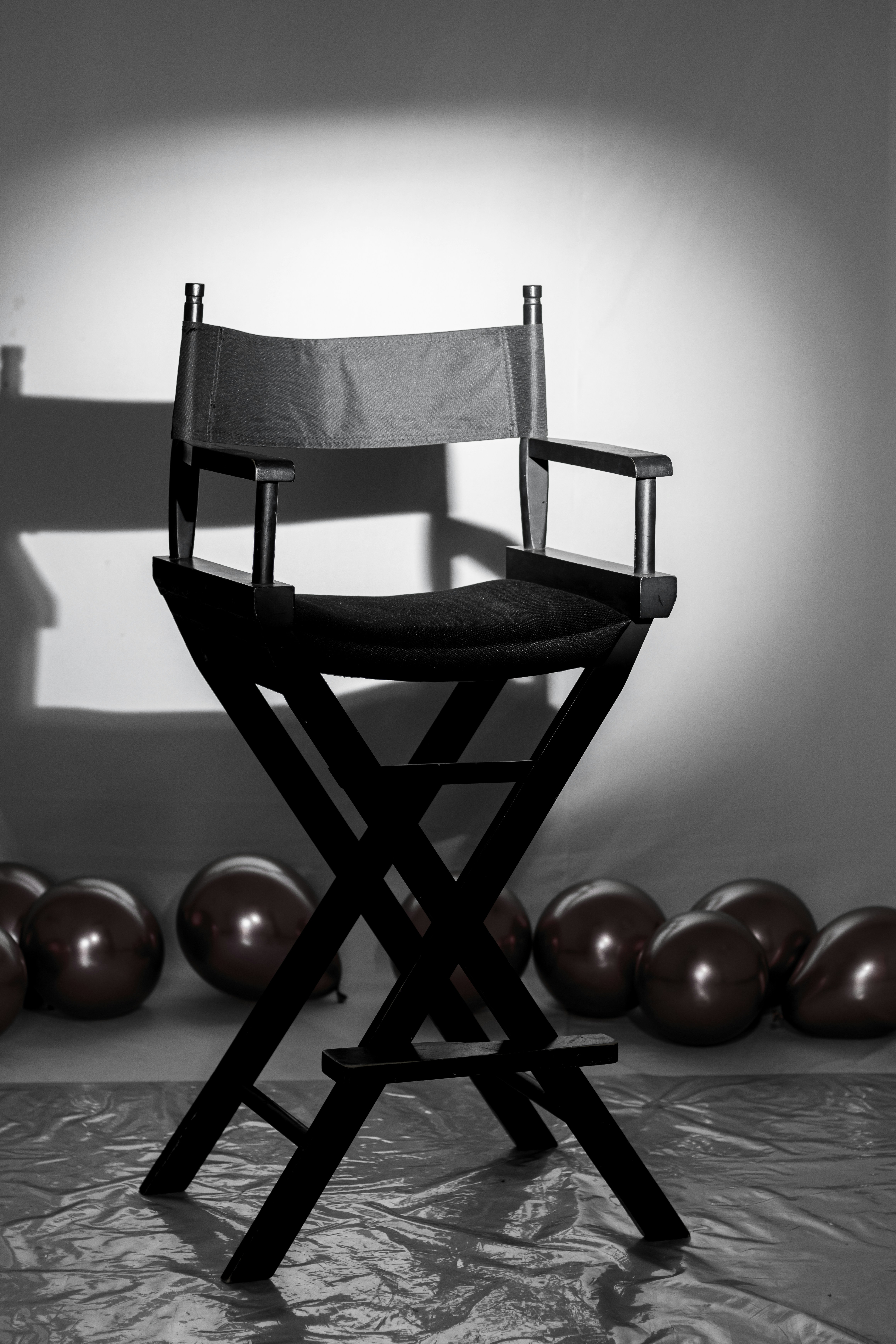 Una silla de director negra con globos detrás.