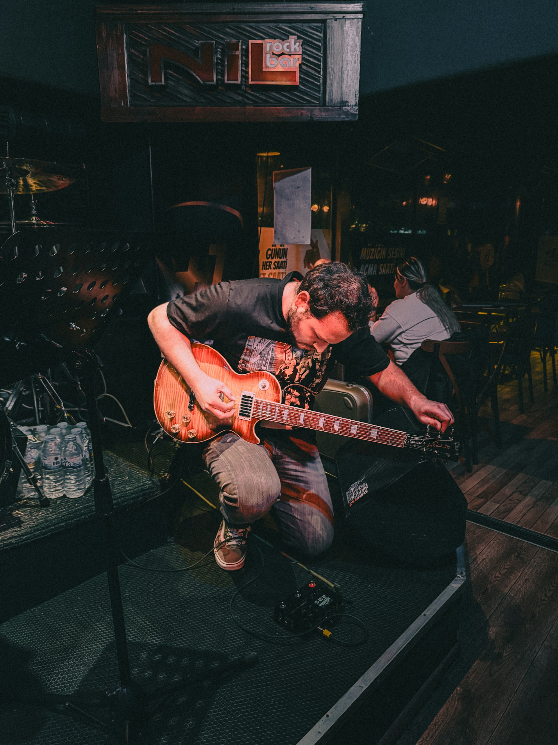 Musician tuning electric guitar on stage