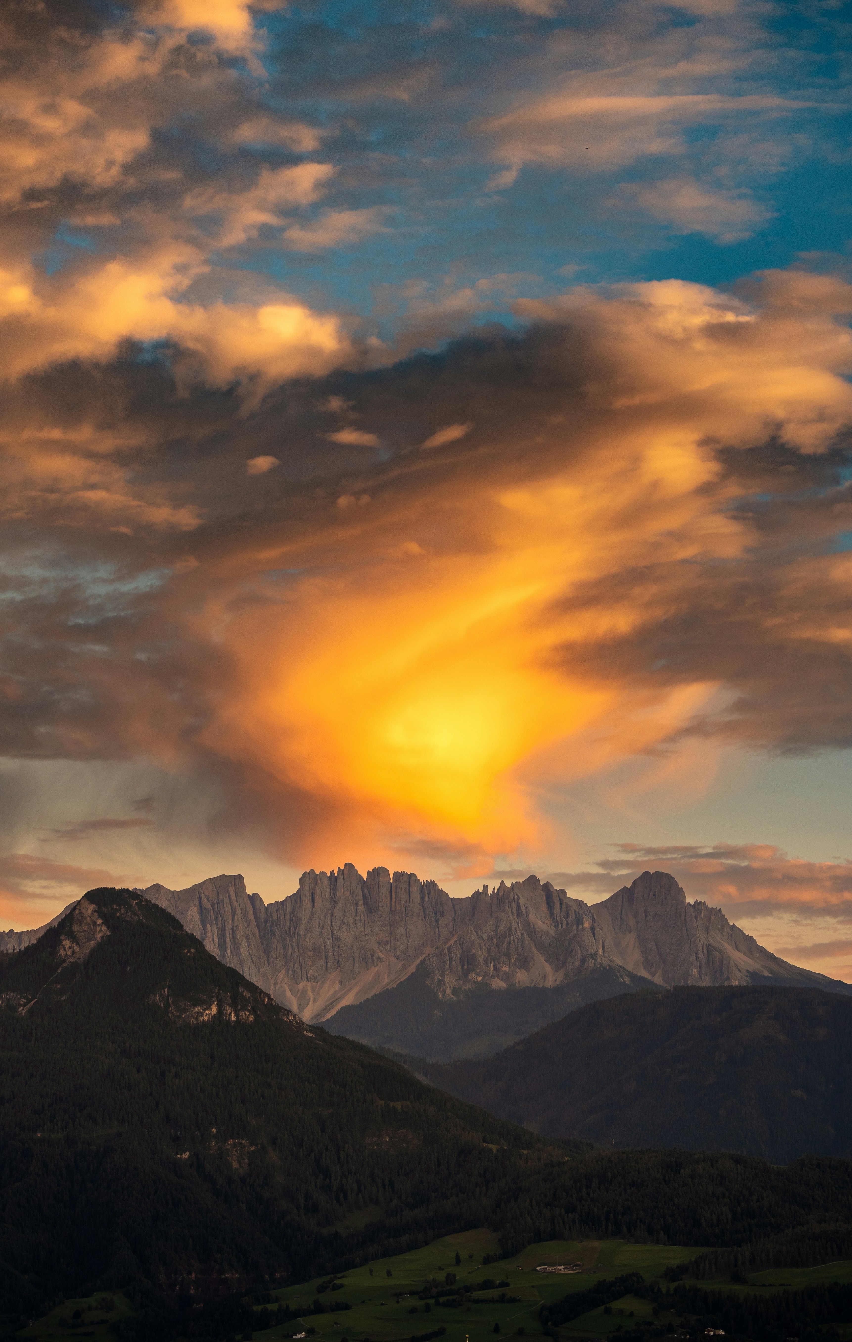 Dramatic sunset clouds over jagged mountain peaks.