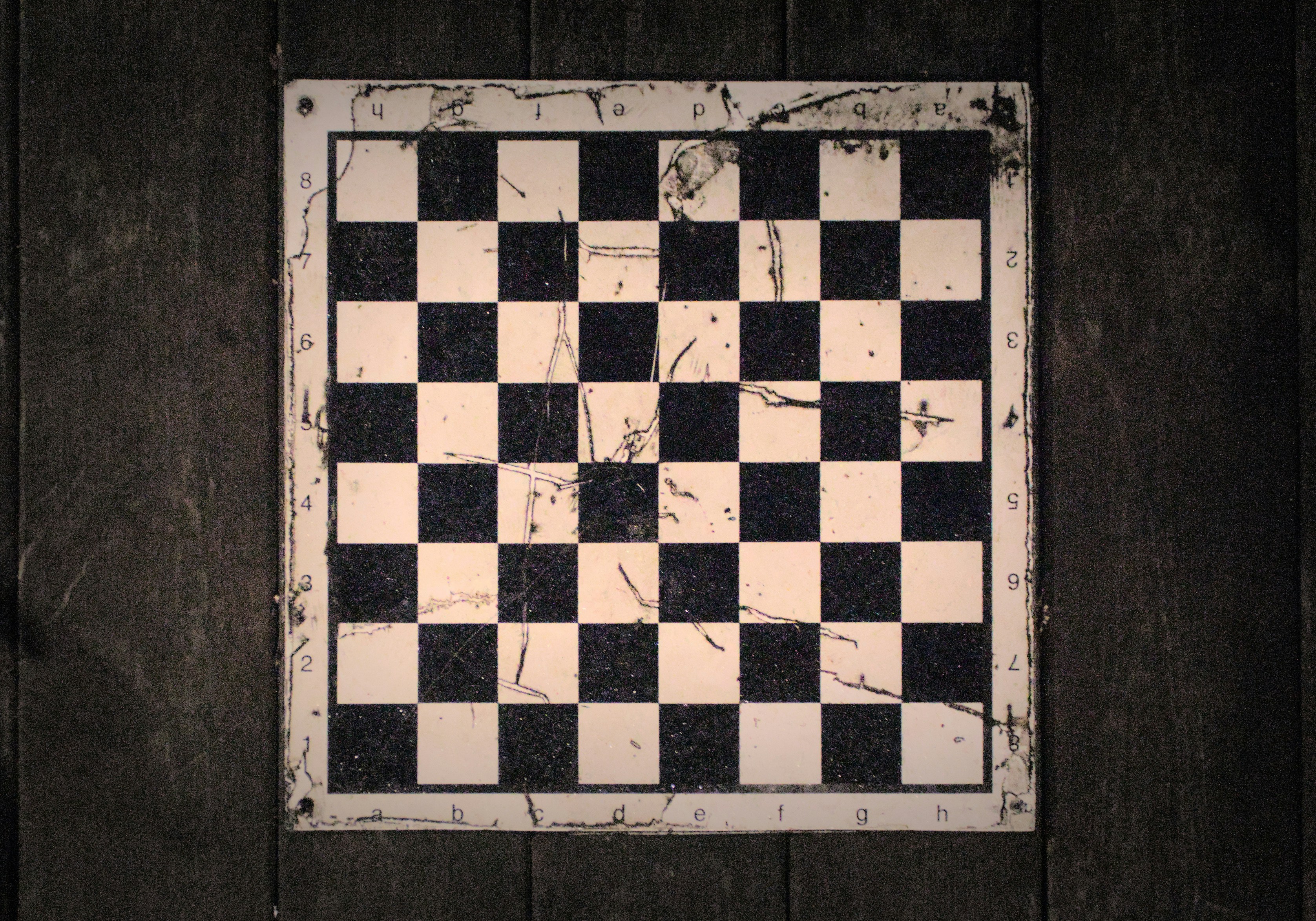 An empty vintage checkerboard on a wooden background
