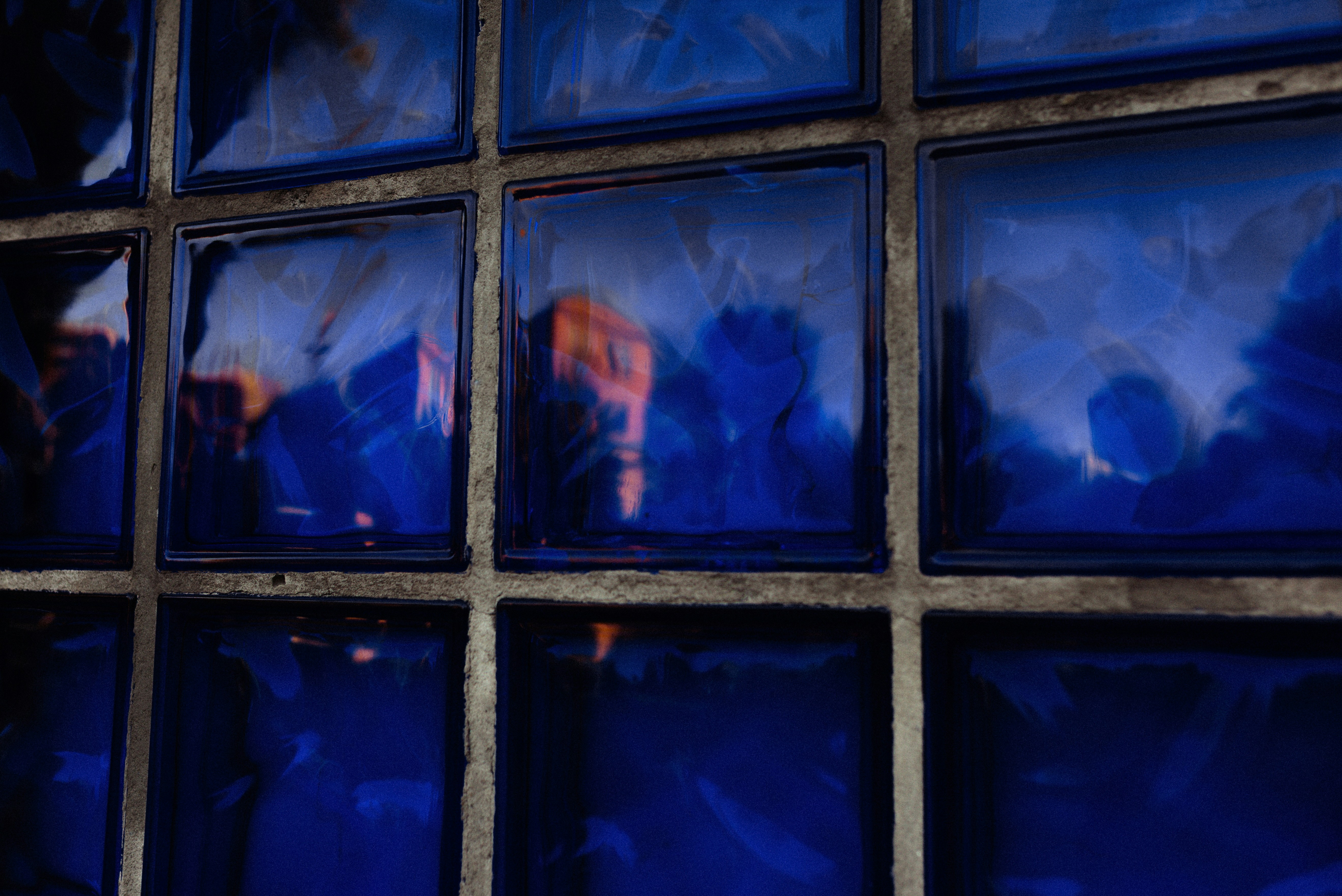 Face reflected in blue glass blocks