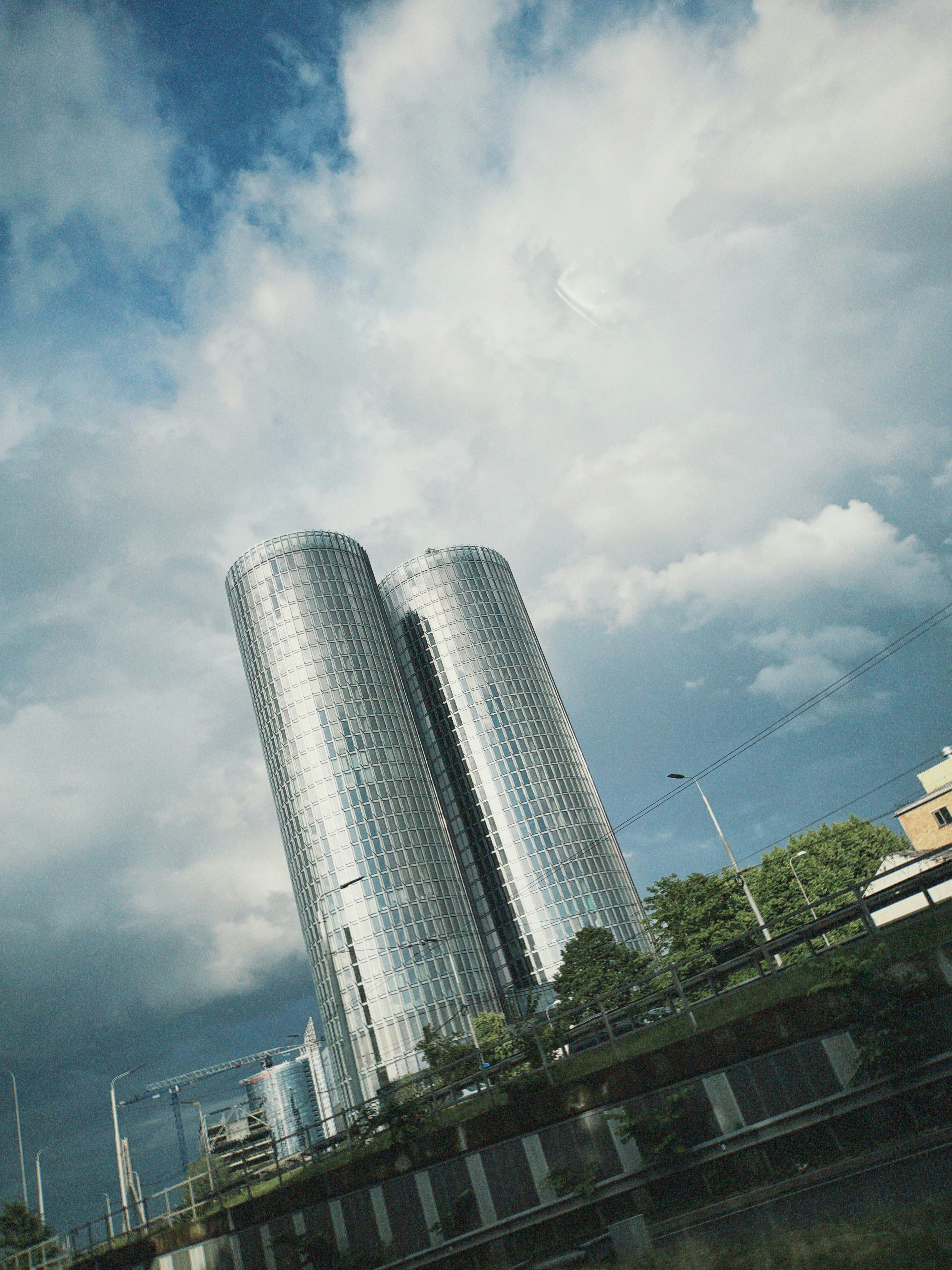 Two modern glass skyscrapers against a cloudy sky