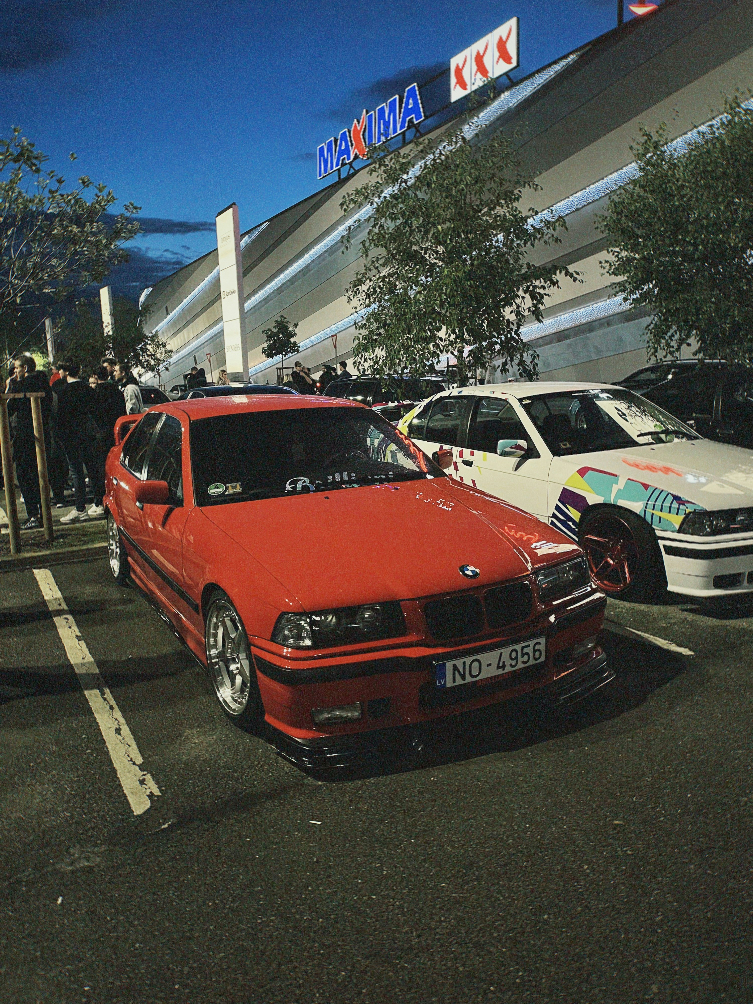 Red BMW parked in a lot at night