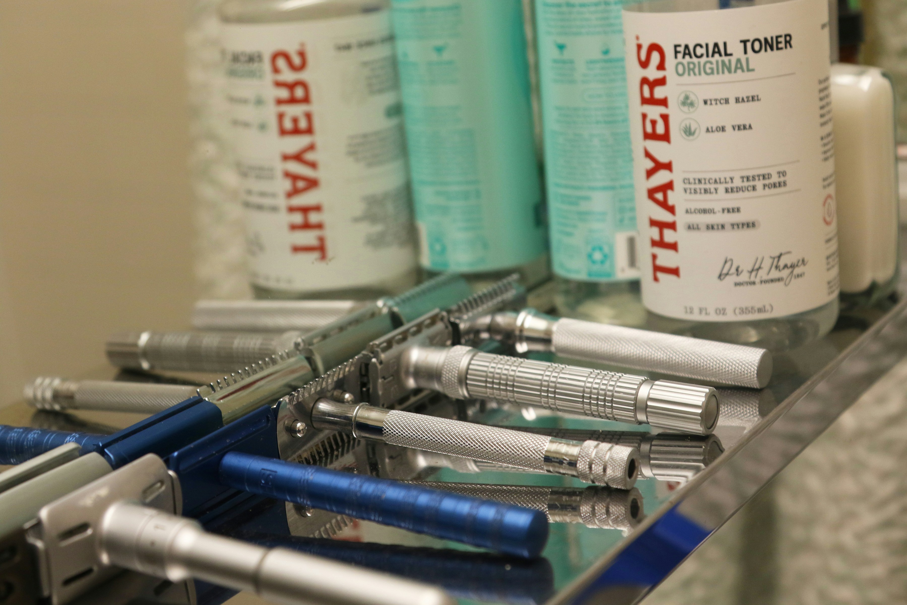 Collection of vintage safety razors and facial toner bottles.