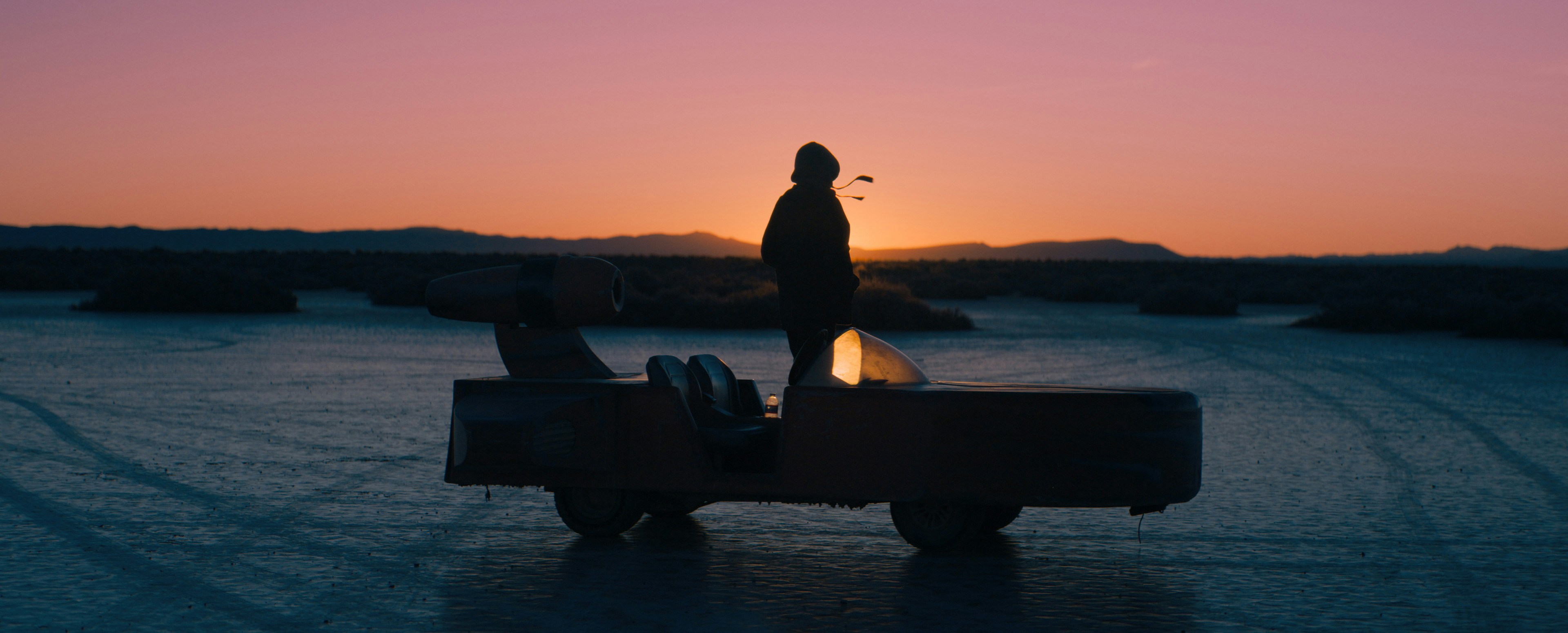 Silhouette of a person on a truck at sunset.