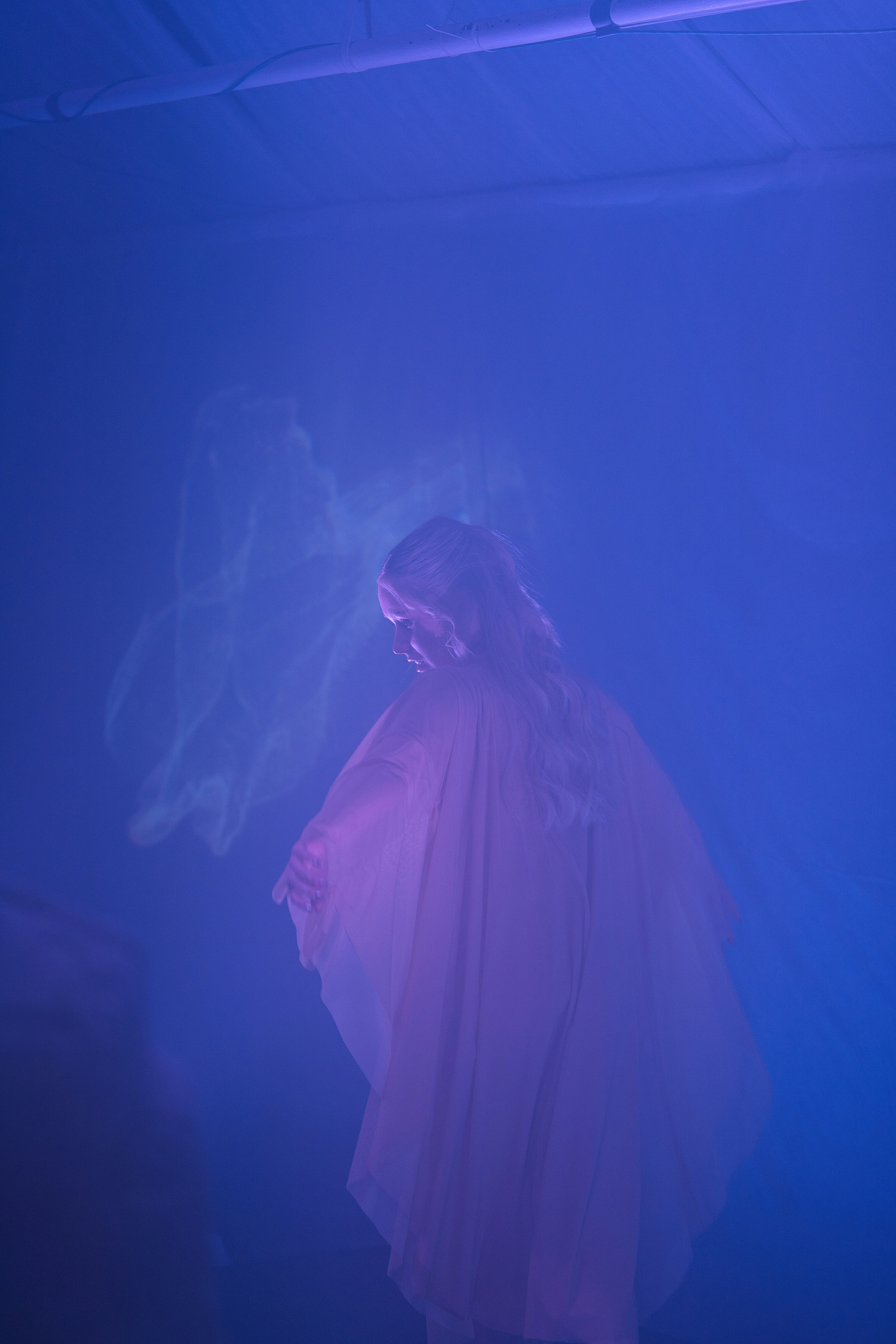 Woman in flowing dress with ethereal smoke effect