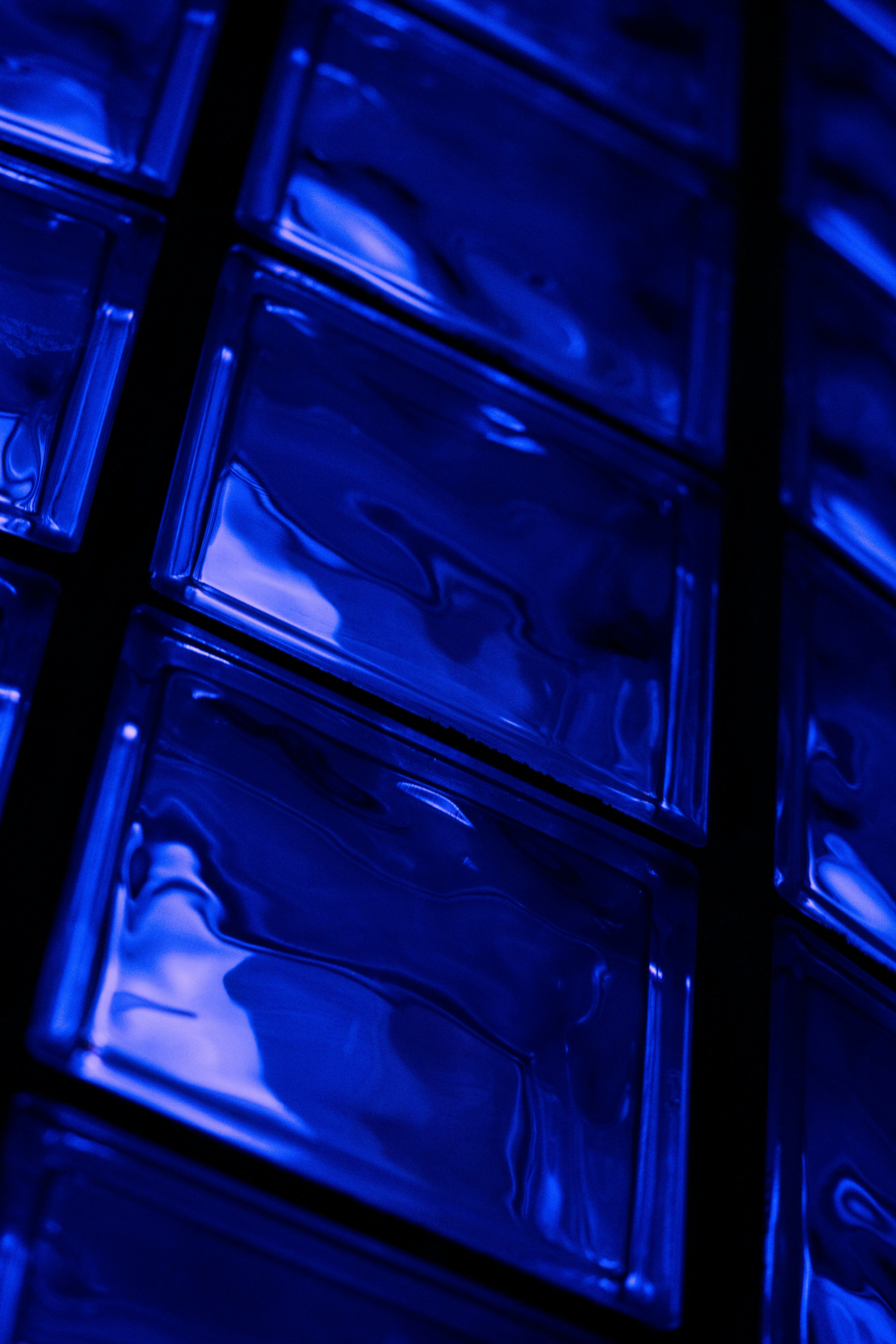 Close-up of blue glass blocks with reflections