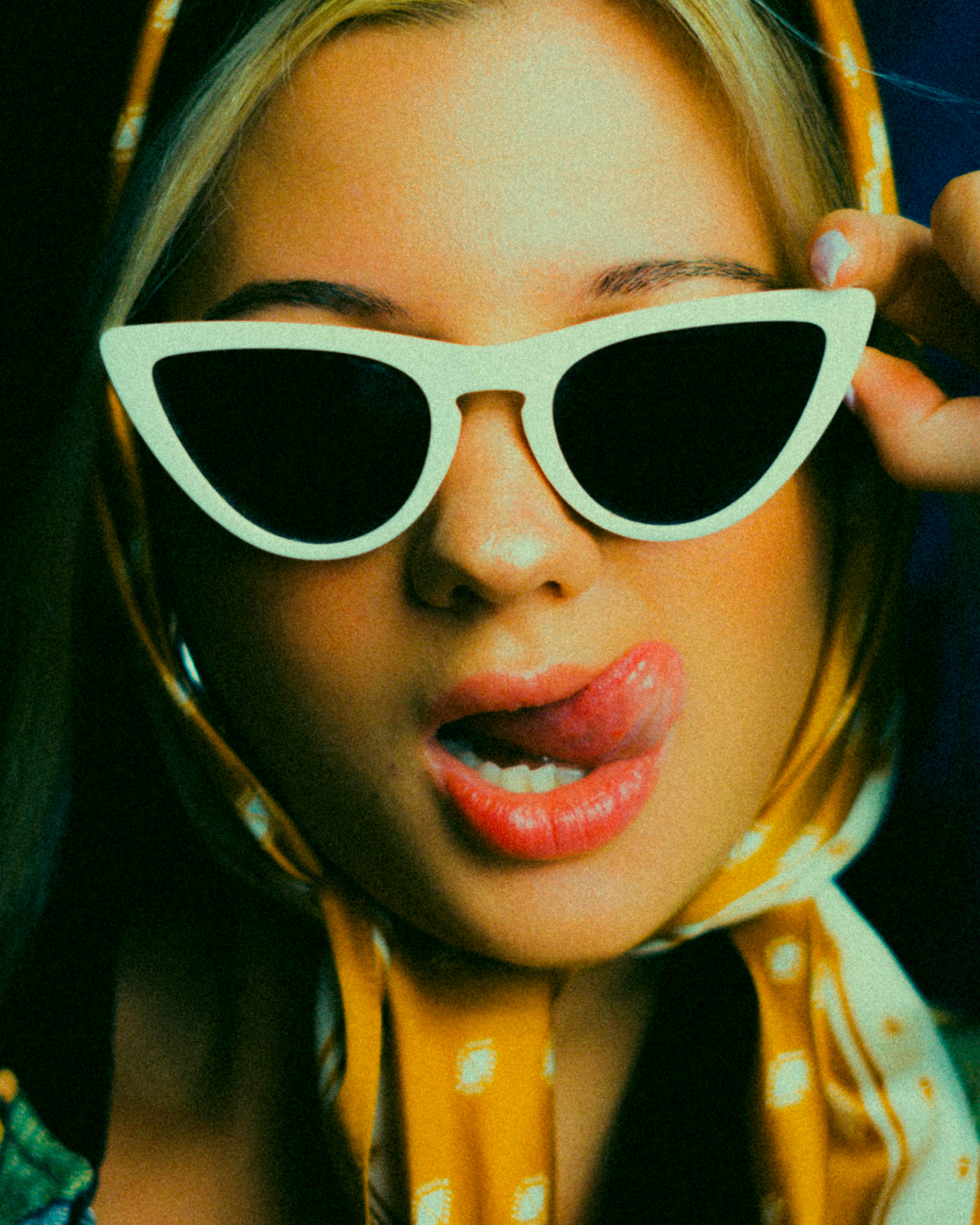 Mulher de óculos escuros mostrando a língua