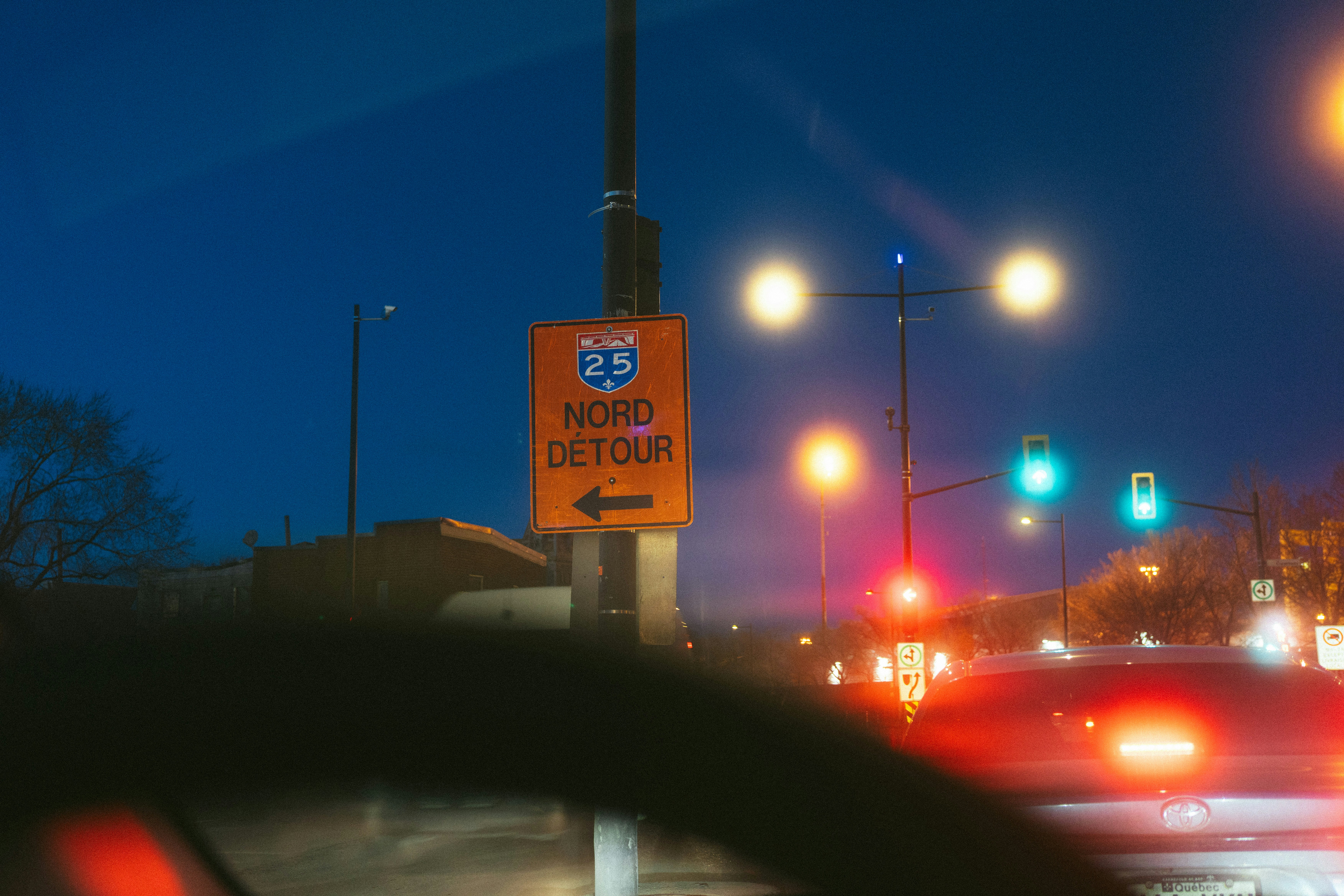 Orange detour sign with arrow at night