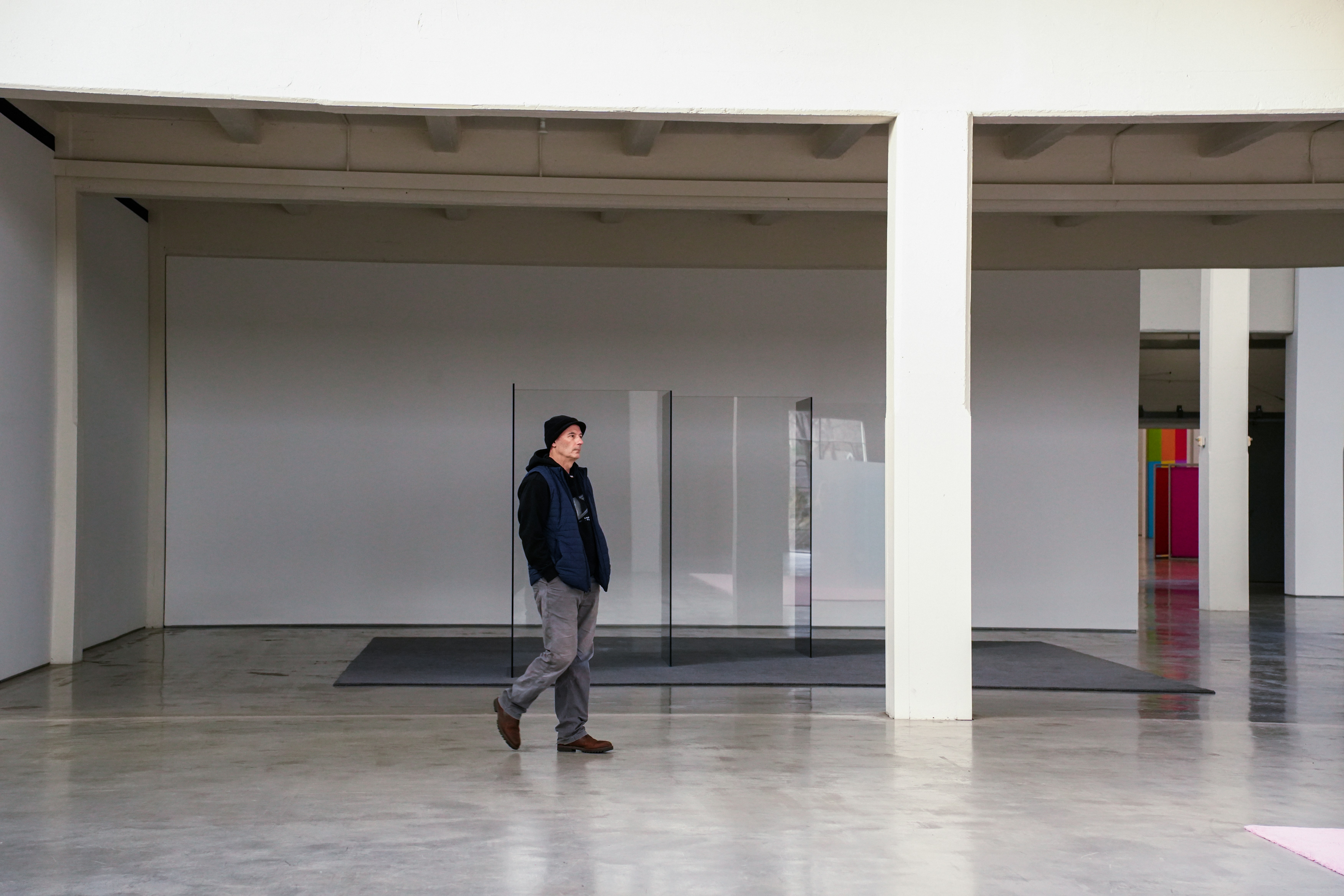 A man walks through a modern art gallery space.