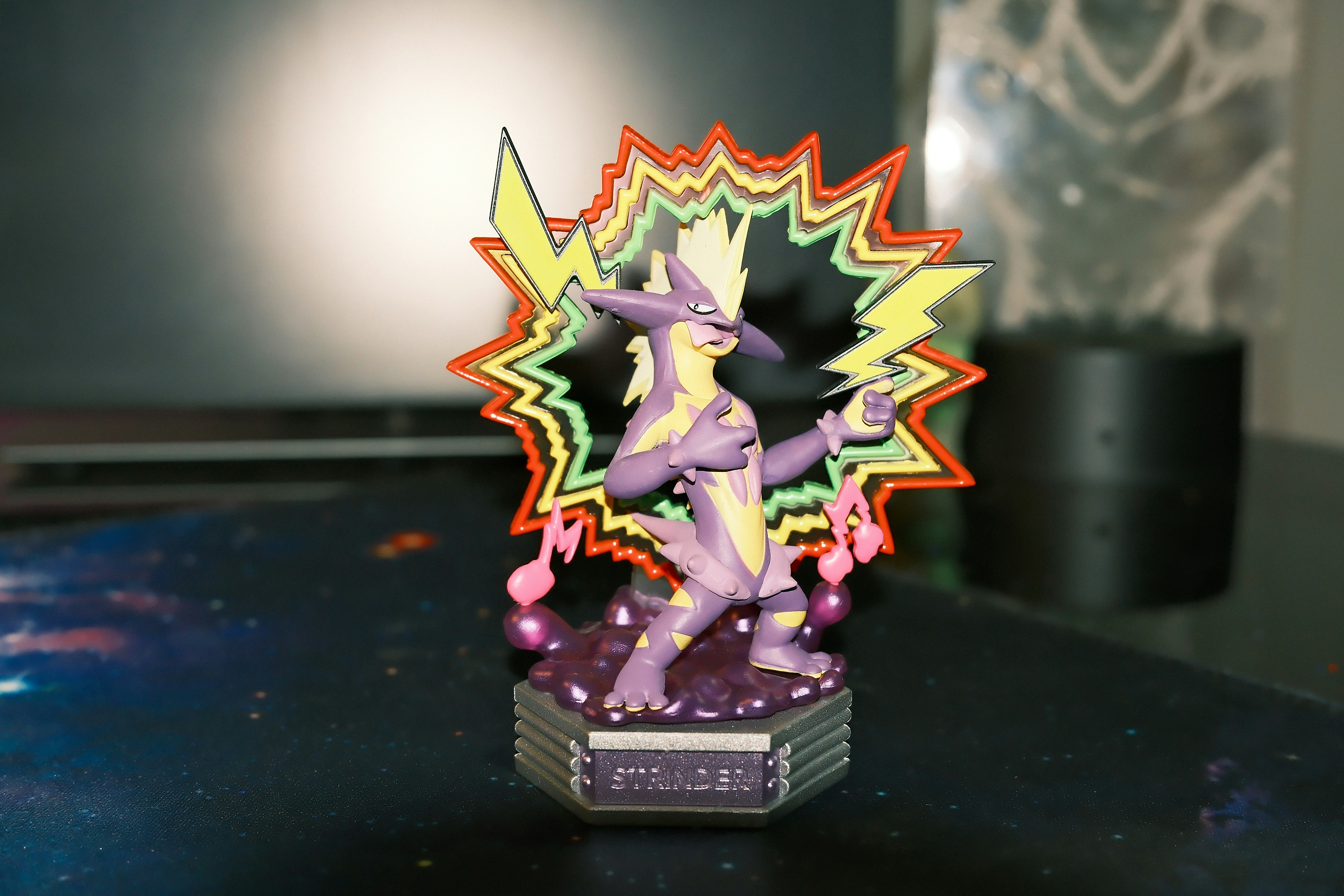 Purple creature figurine with lightning and music notes.