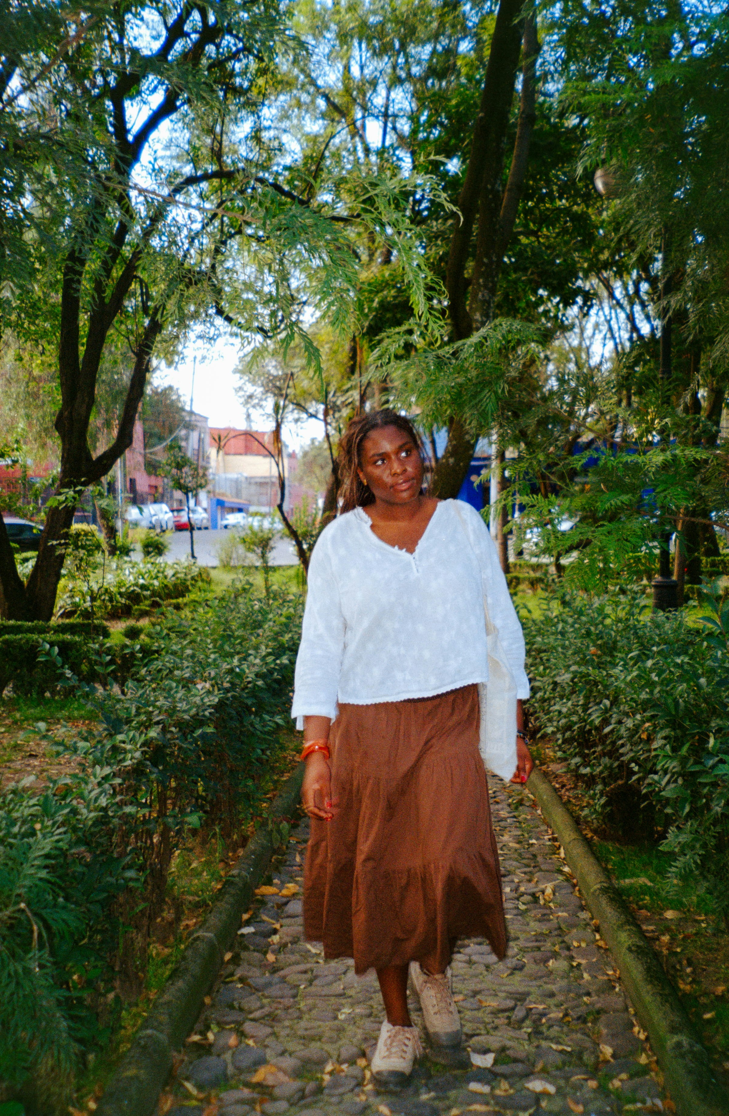 A woman walks on a stone path in a park. photo – Free Trees Image on ...