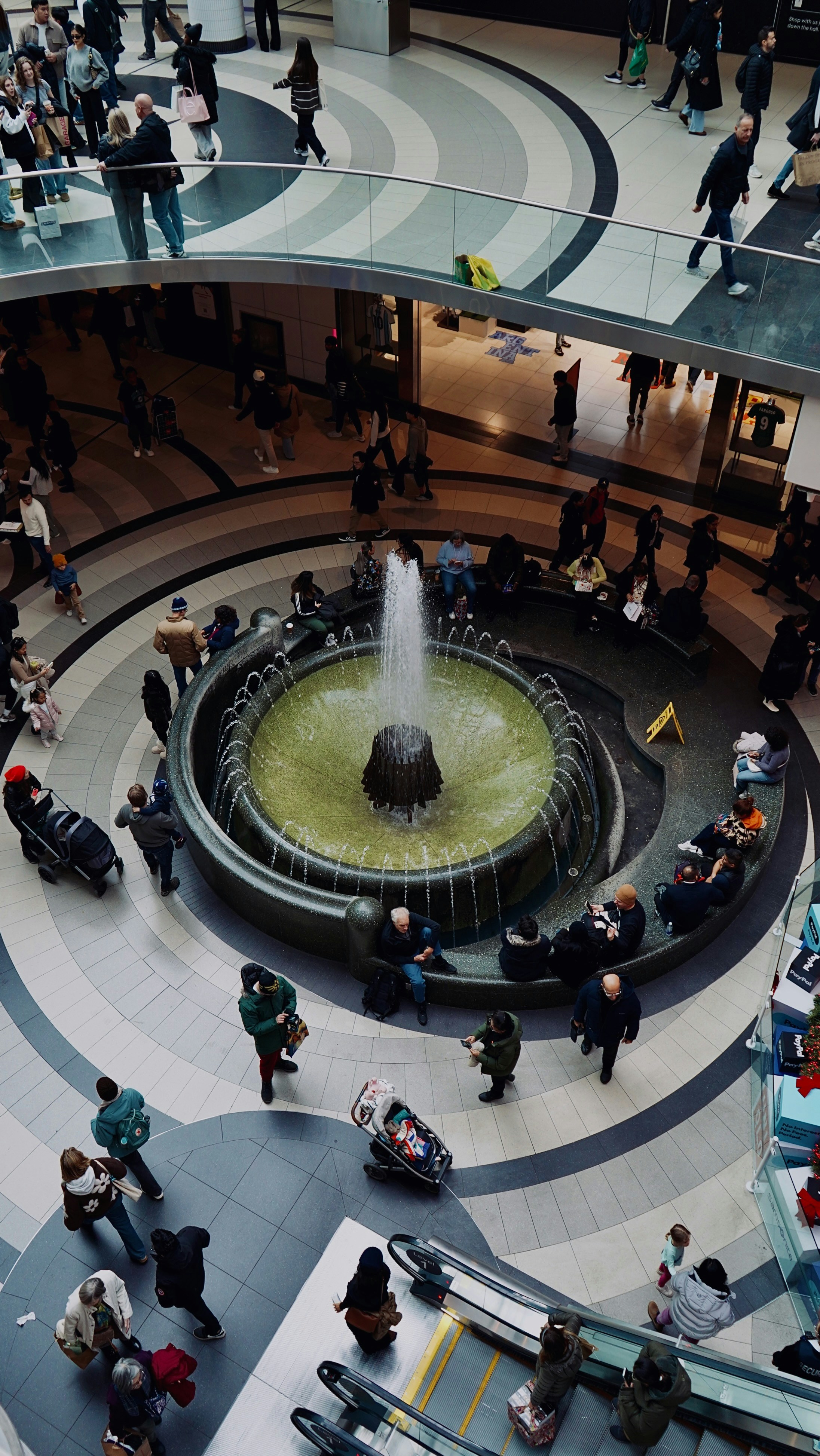People gathered around a fountain in a modern building.