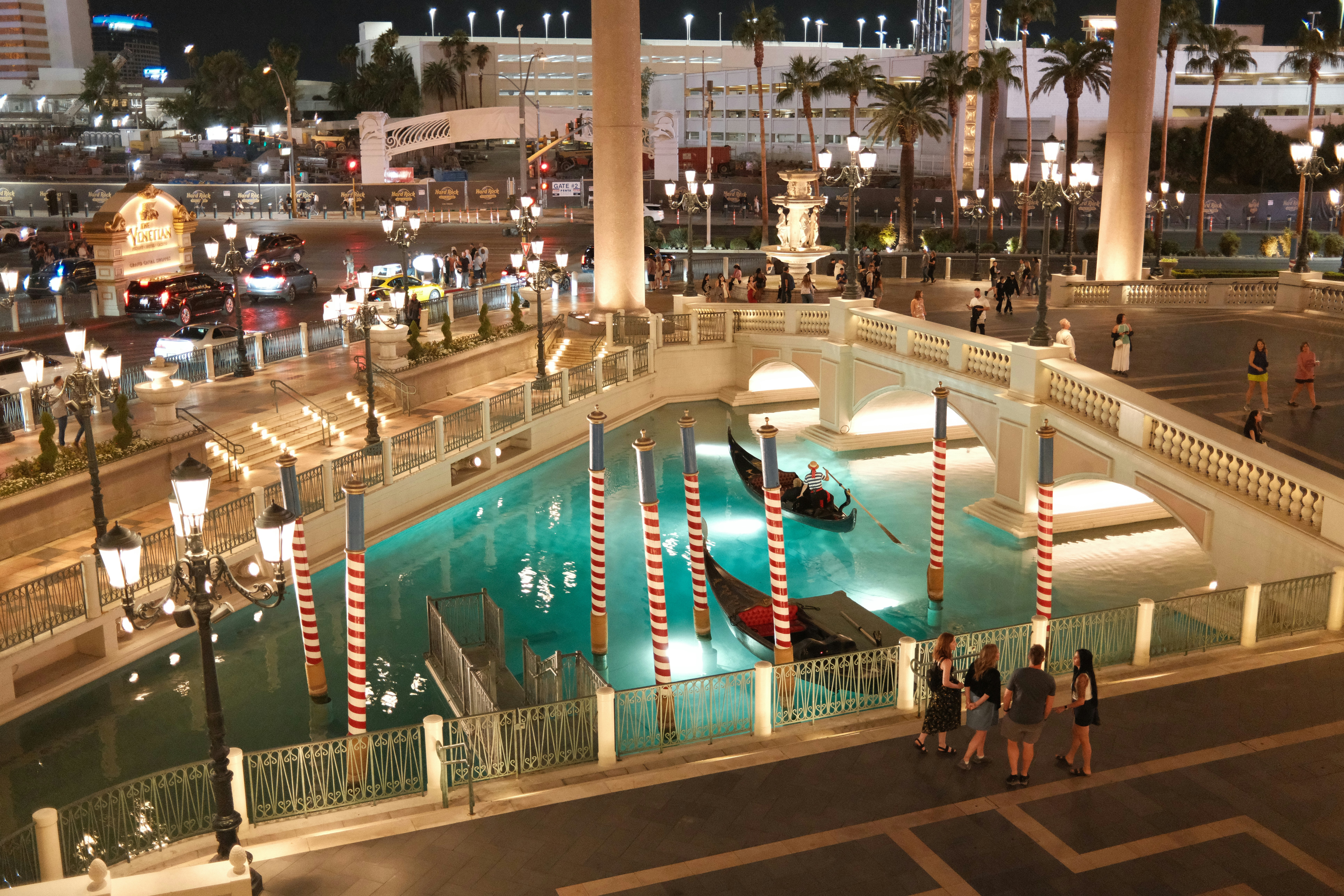 Gondolas float on a canal at night.