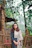 Young woman standing outdoors near a wooden fence.