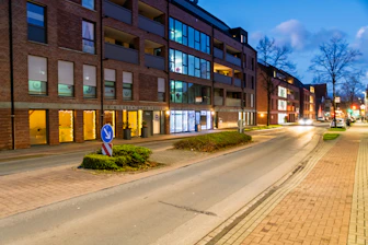 Street scene with modern buildings at dusk.