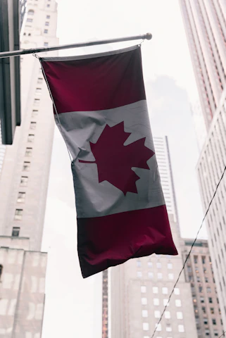 Canadian flag hanging between tall buildings