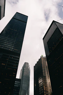 Tall modern skyscrapers against a cloudy sky.