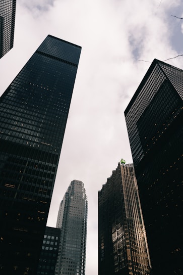 Tall modern skyscrapers against a cloudy sky.