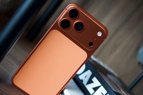 Close-up of a copper-colored smartphone with three cameras