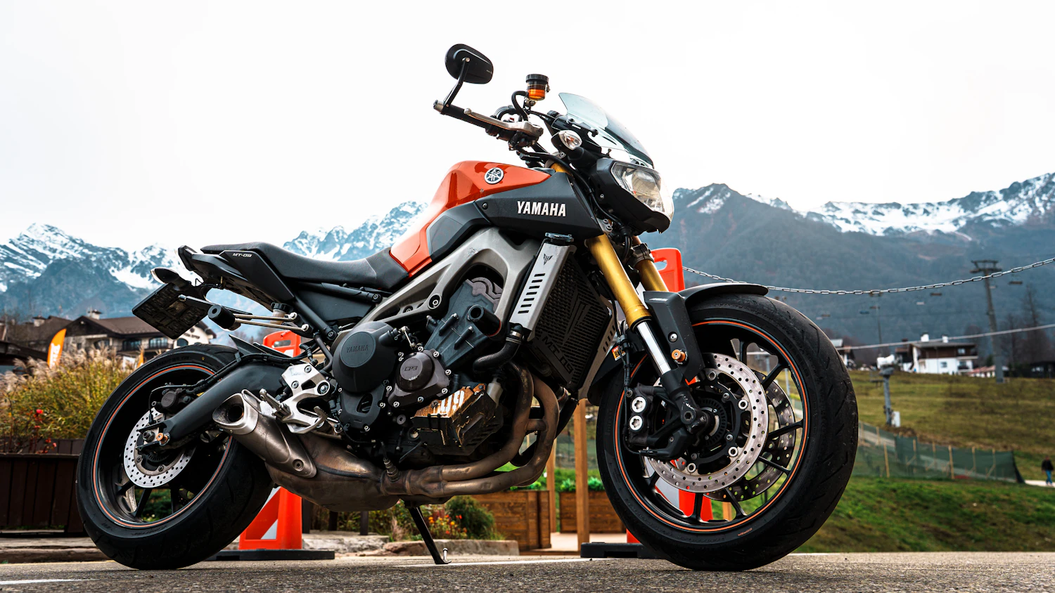 Full-power naked motorcycle parked with snowy mountains behind