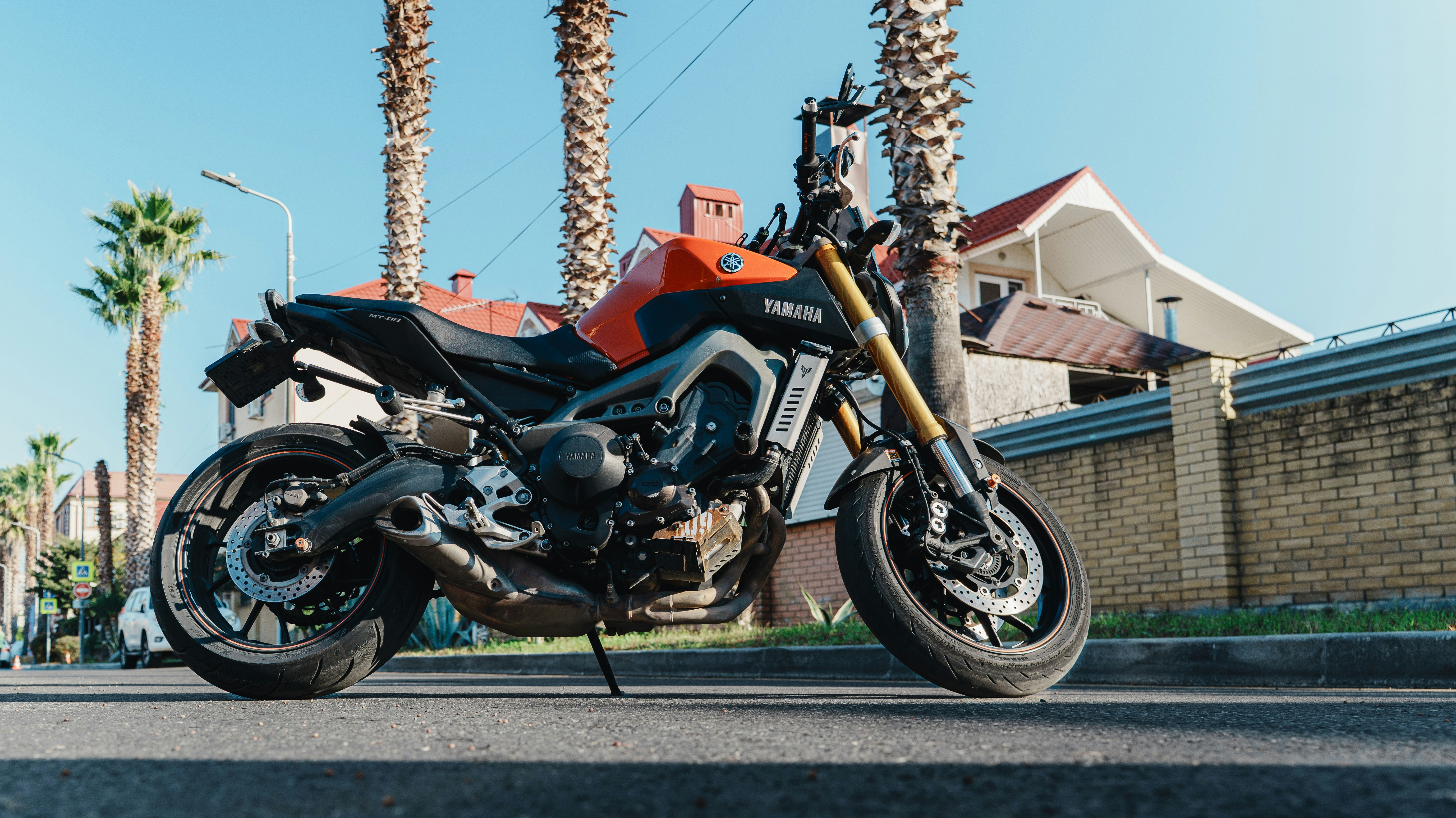 Orange motorcycle parked on a sunny street