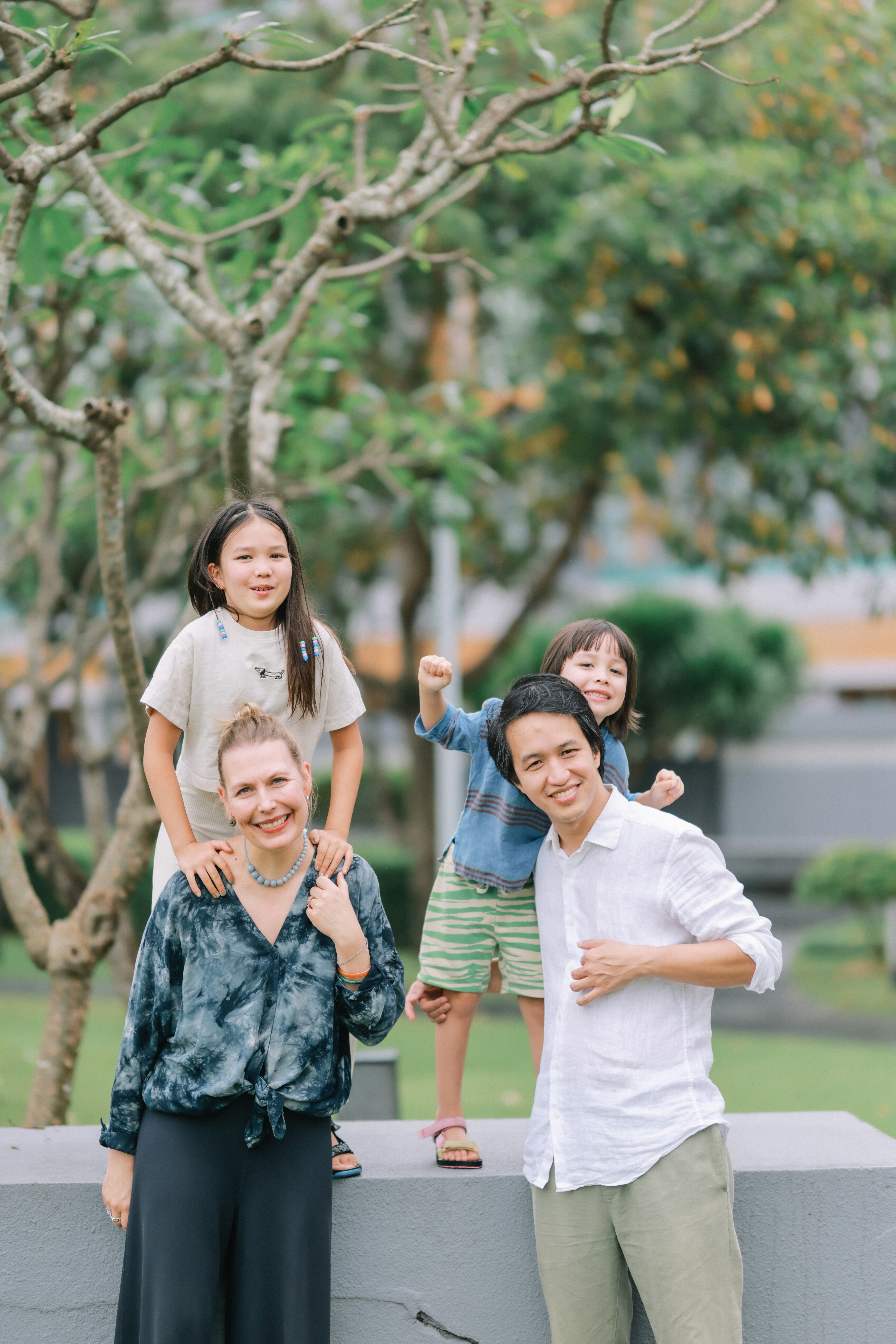 Eine glückliche Familie, die zusammen in einem Park posiert.